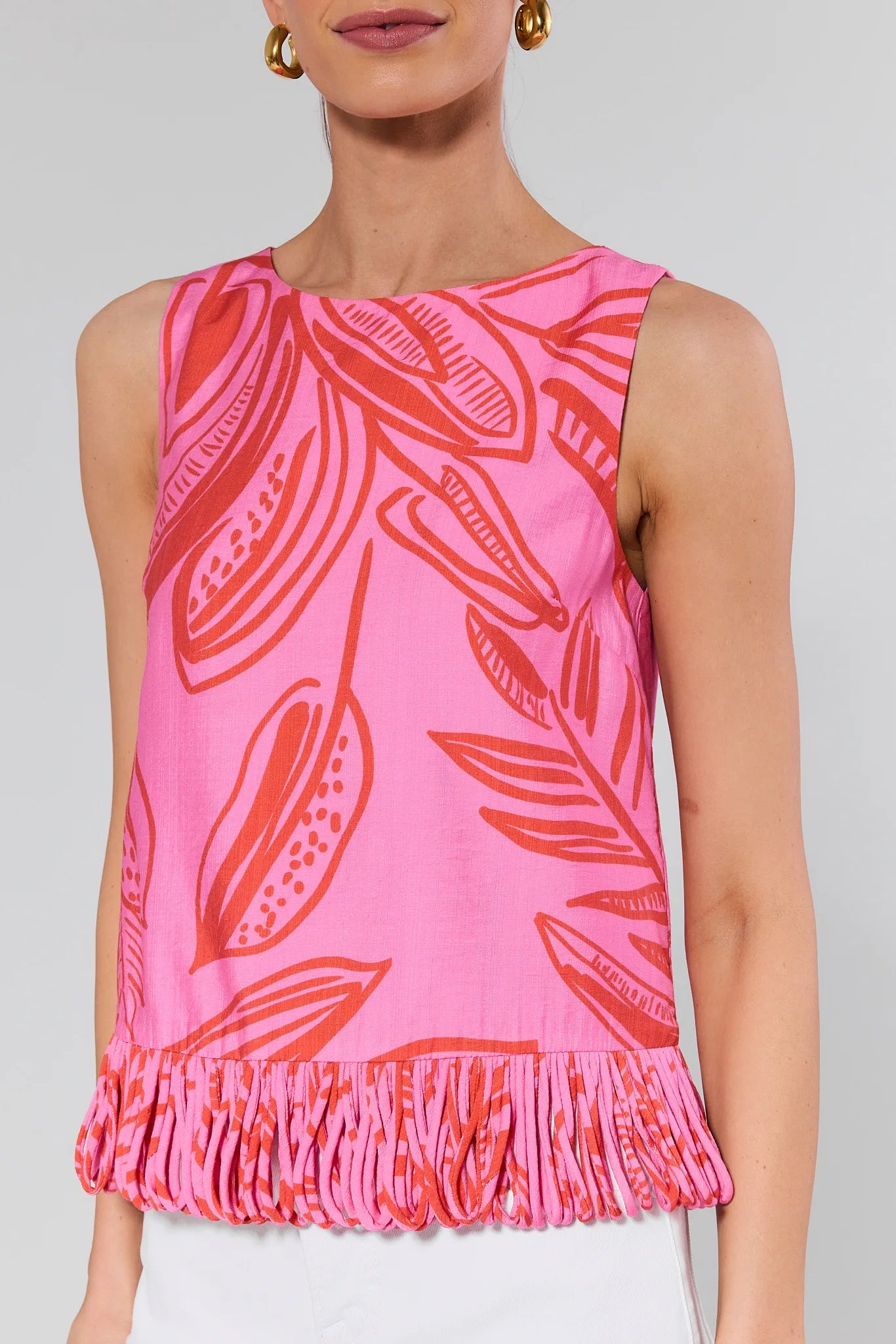 Pink sleeveless top with red leaf pattern on a plain background