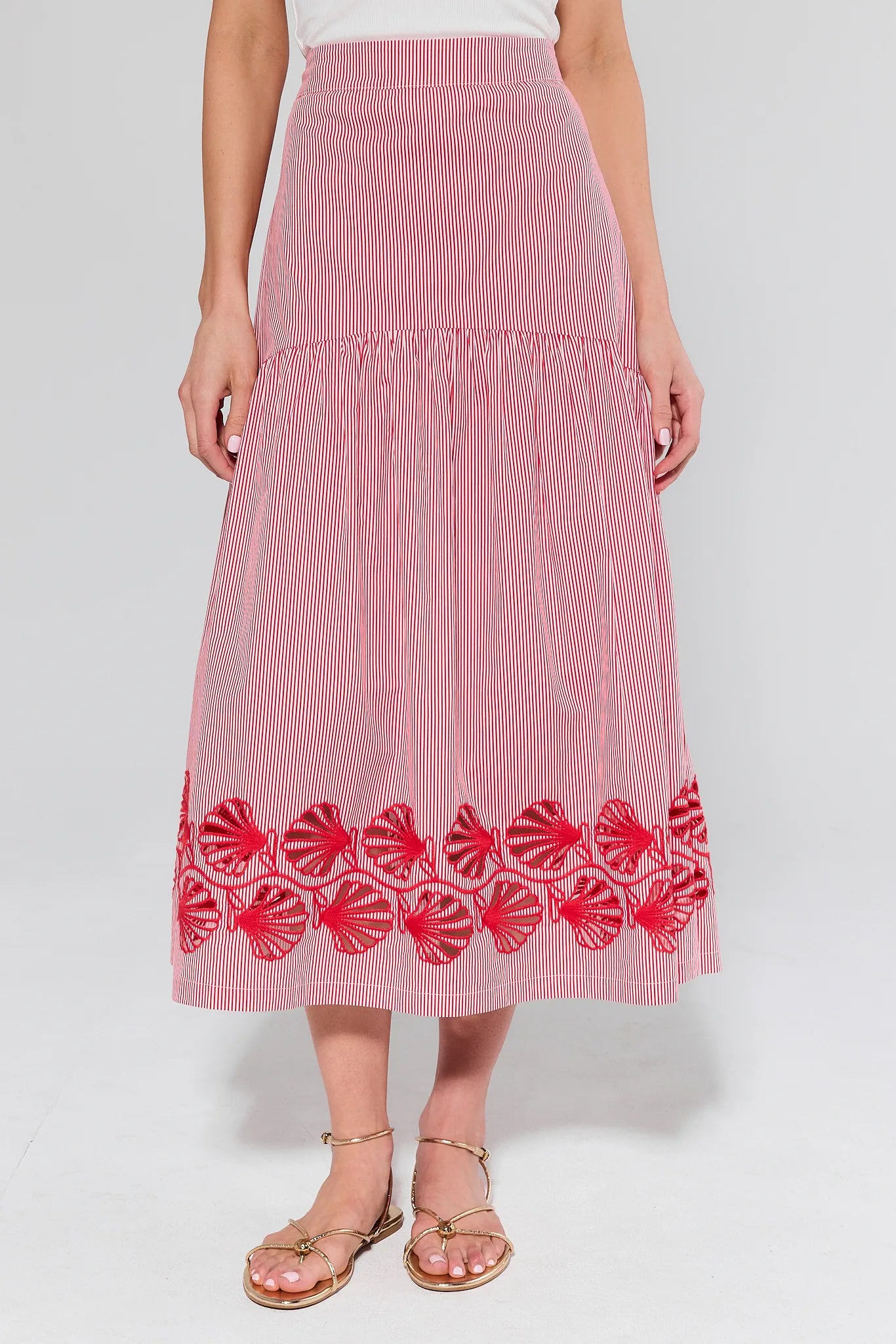 Red and white striped skirt with floral embroidery on a plain background