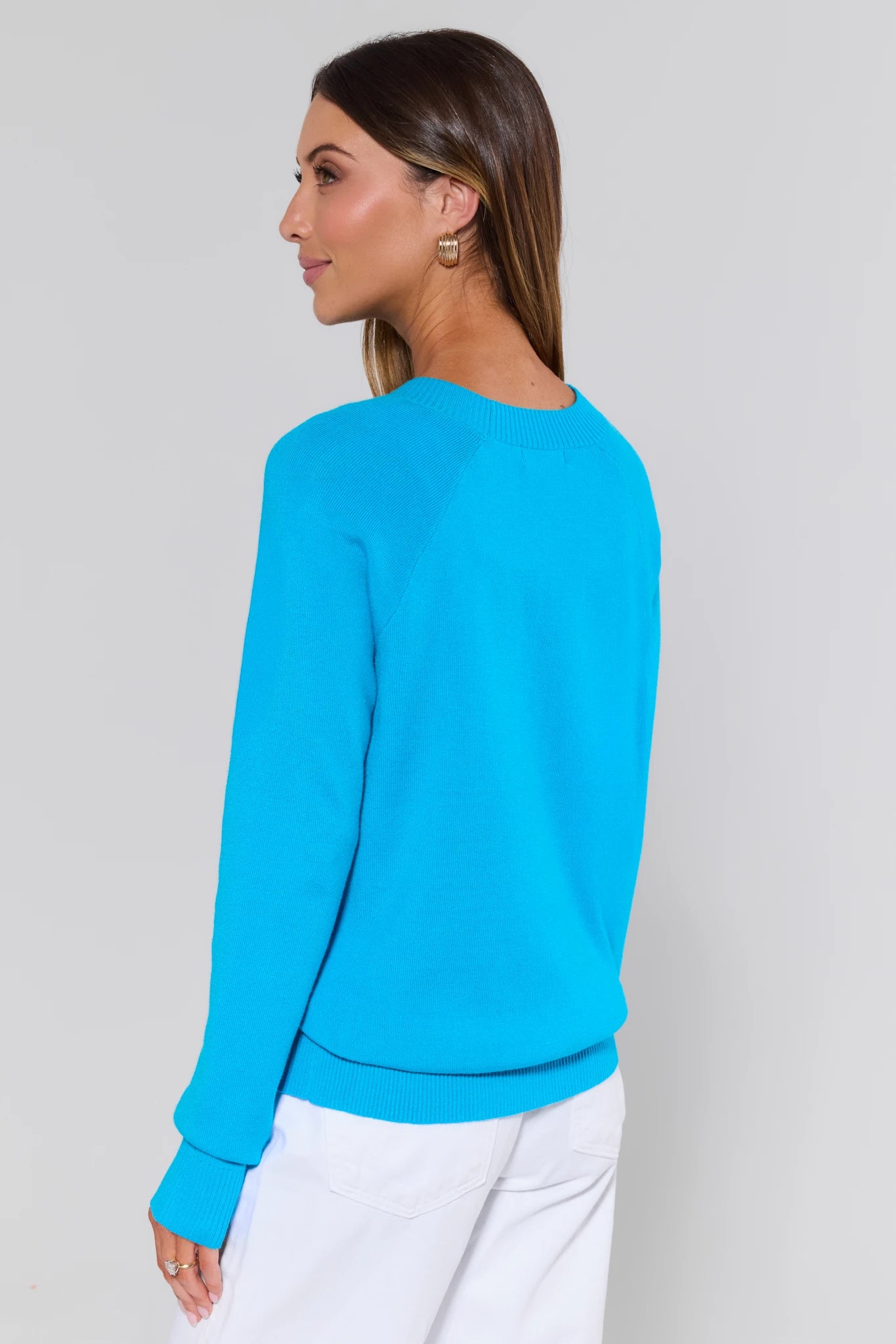 Woman wearing a bright blue sweater against a plain background