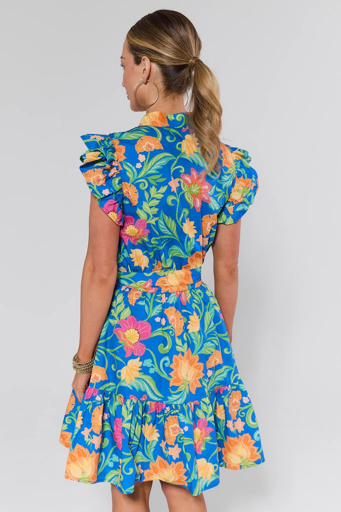 Woman wearing a colorful floral dress on a white background