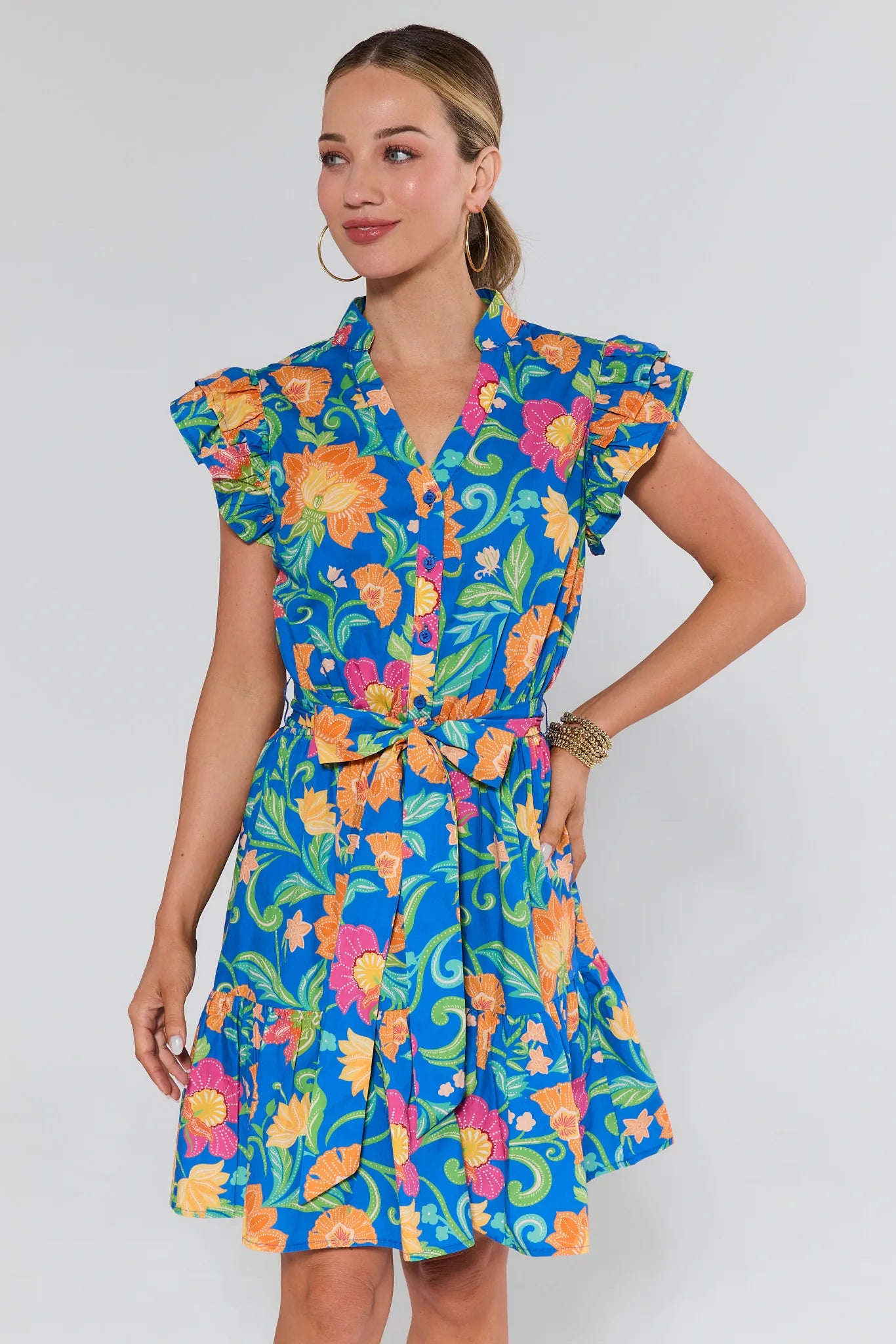 Woman wearing a colorful floral dress against a white background