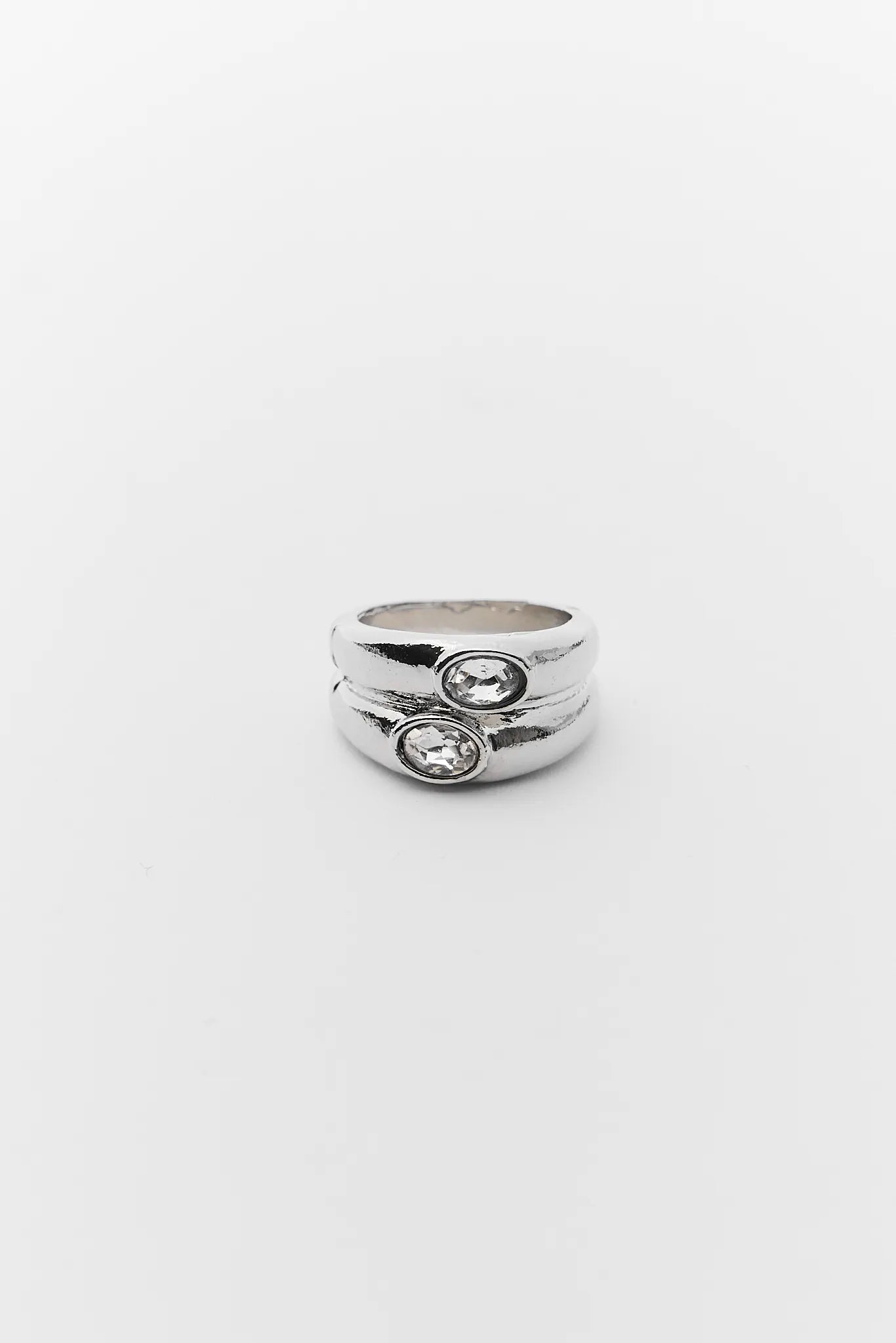 Stack of silver rings with embedded stones on a white background