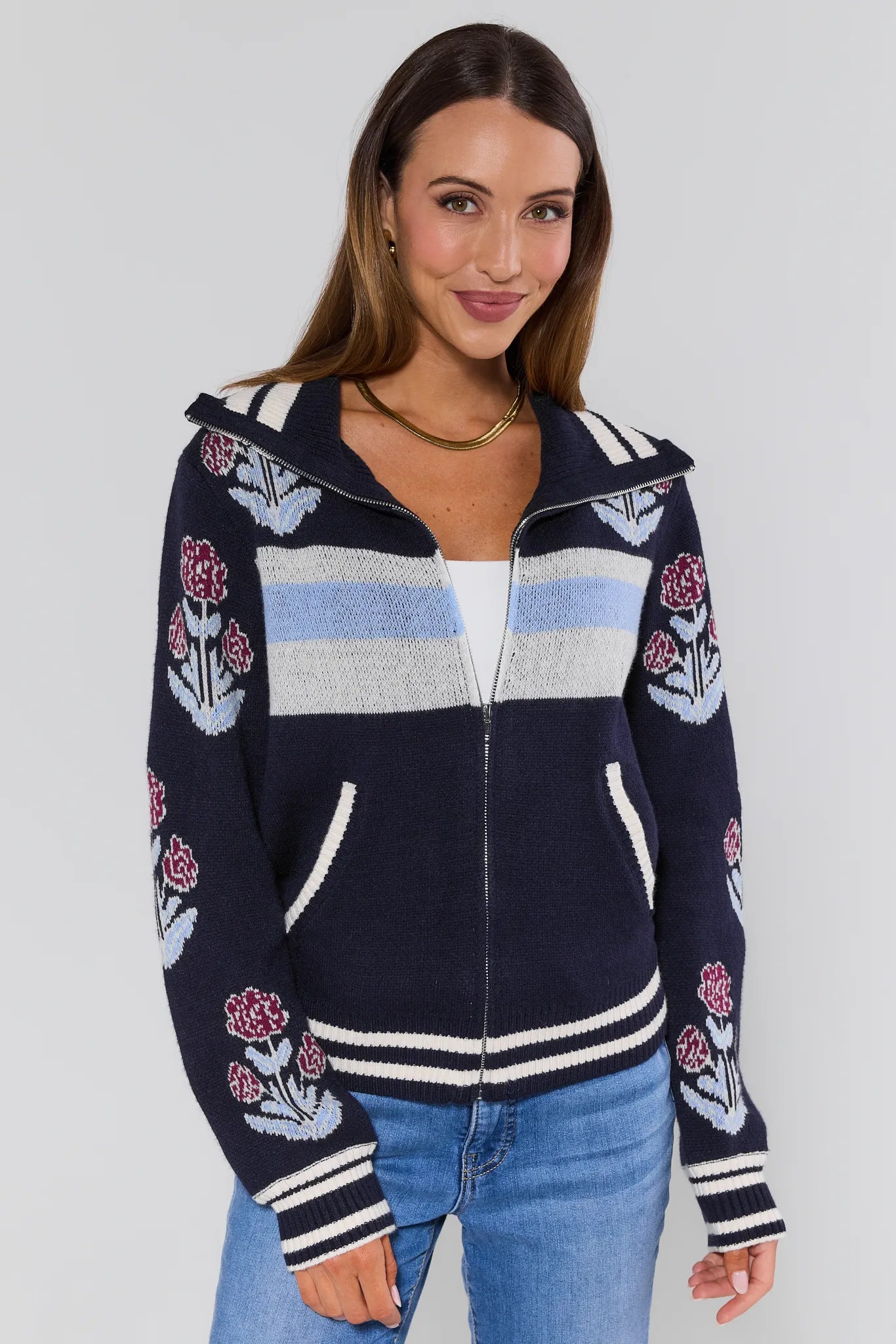 Woman wearing a Corrine Floral Zip Up Cardigan navy blue with floral patterns on a plain background