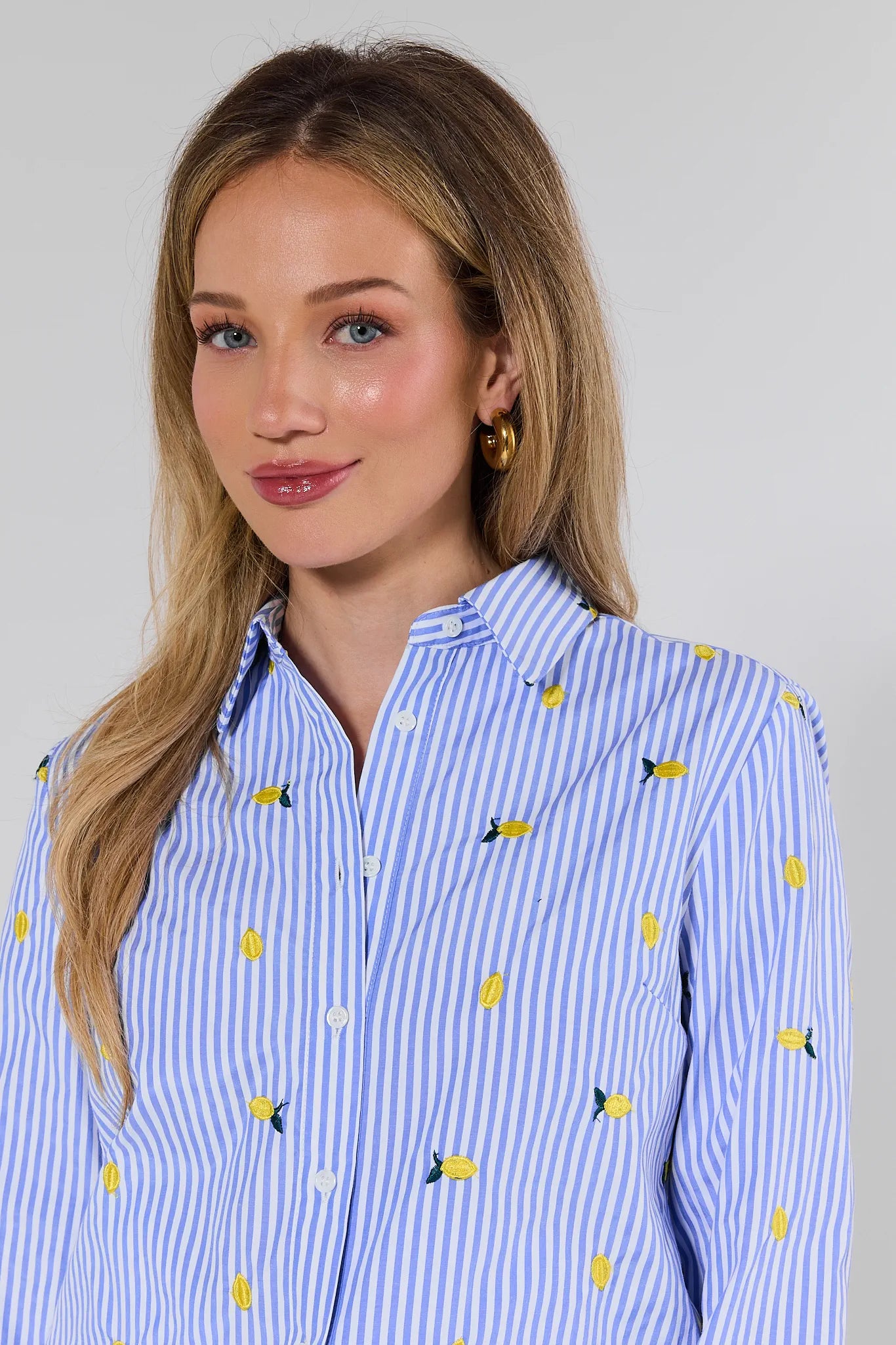 Woman wearing a blue and white striped shirt with yellow and black pattern