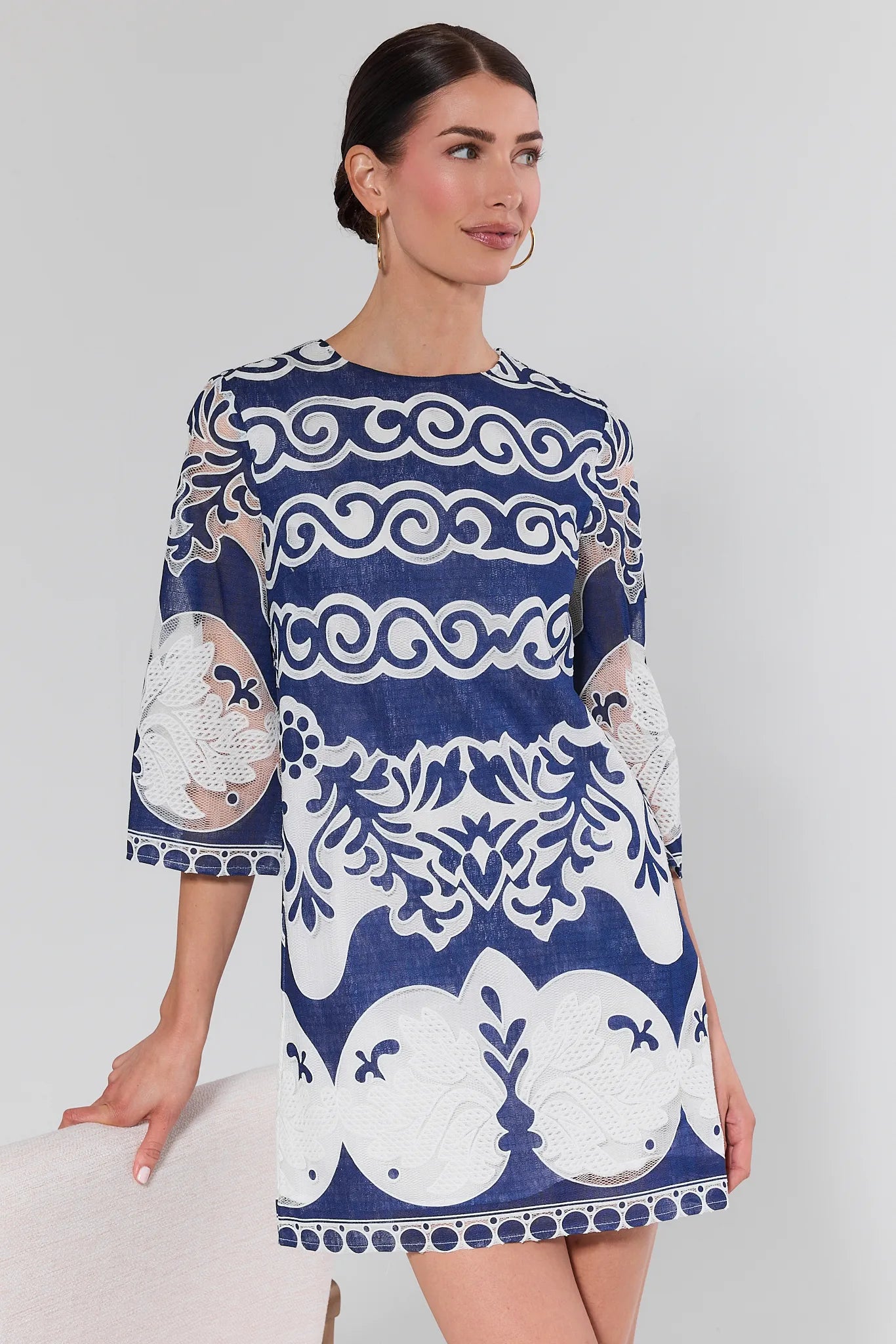 Woman wearing a blue and white patterned dress on a plain background