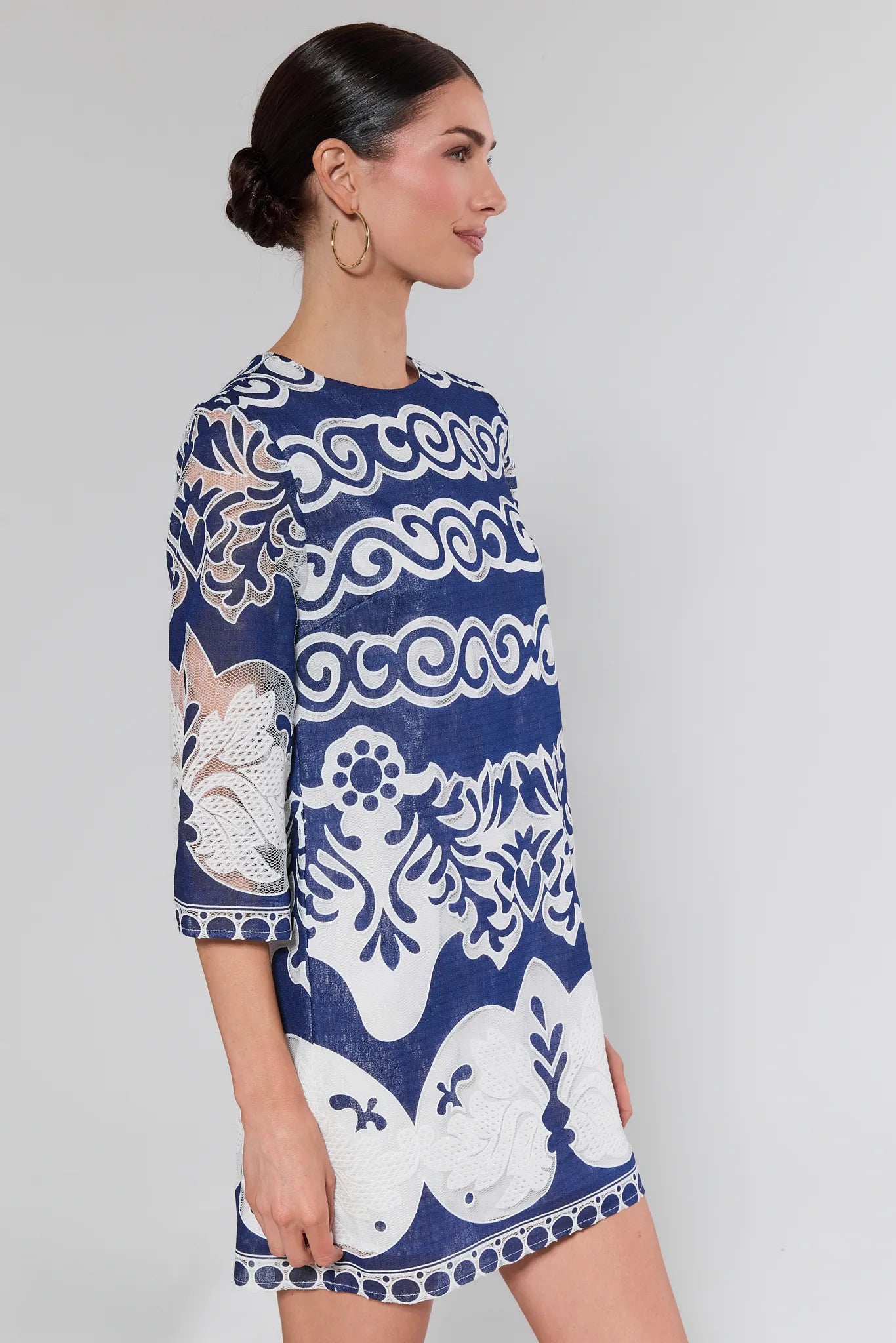 Woman wearing a blue and white patterned dress on a plain background