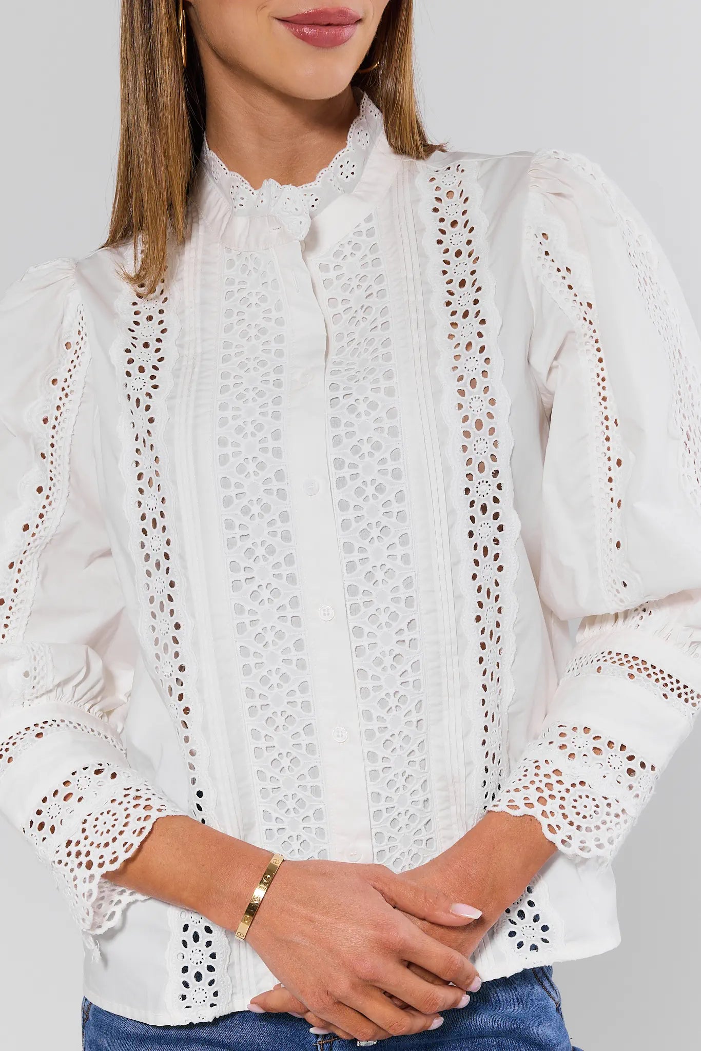White lace blouse worn by a person on a gray background