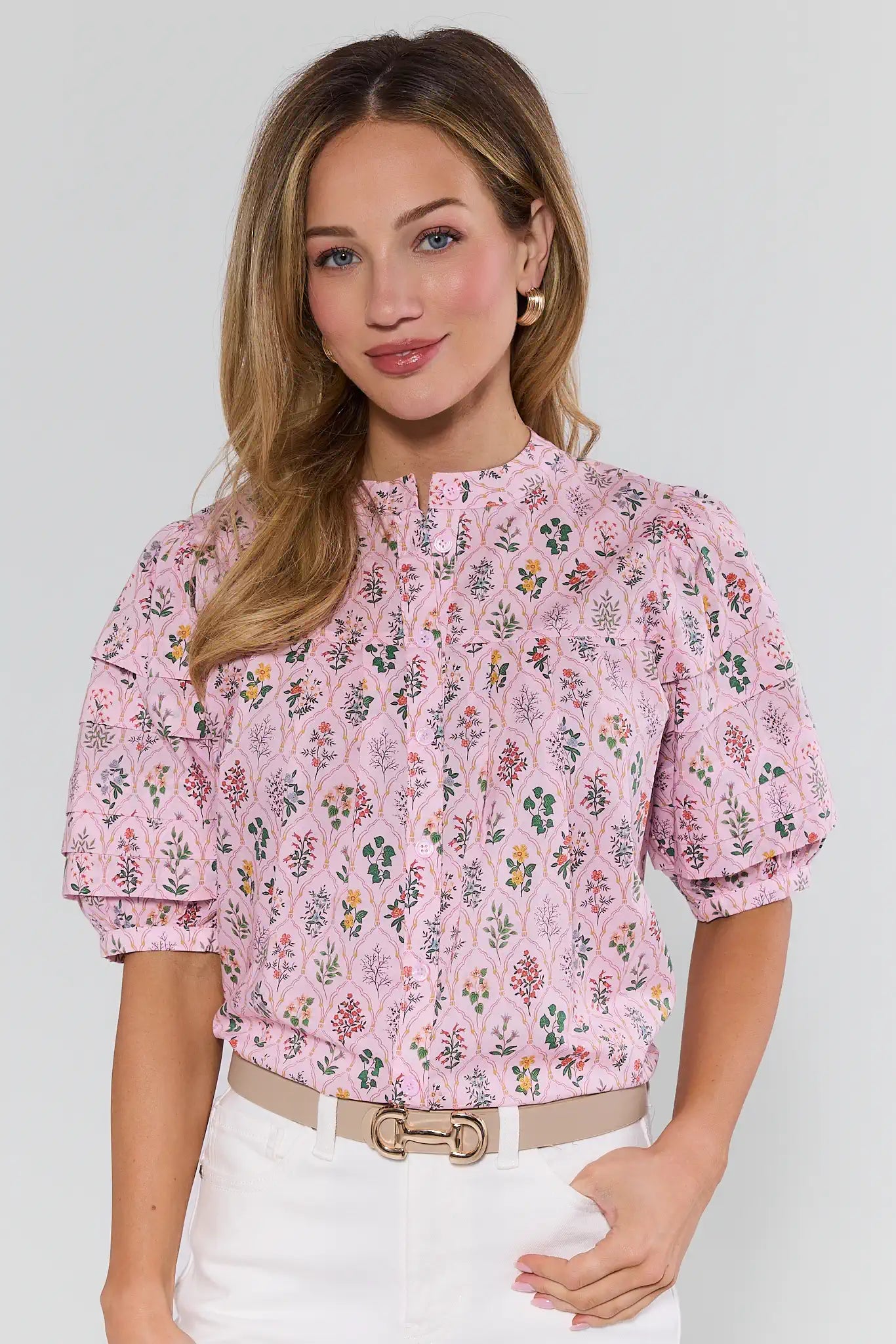Woman wearing a pink floral blouse against a white background