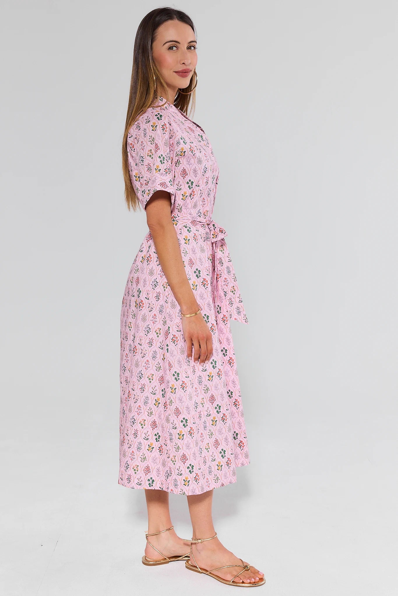 Woman wearing a pink floral dress on a white background