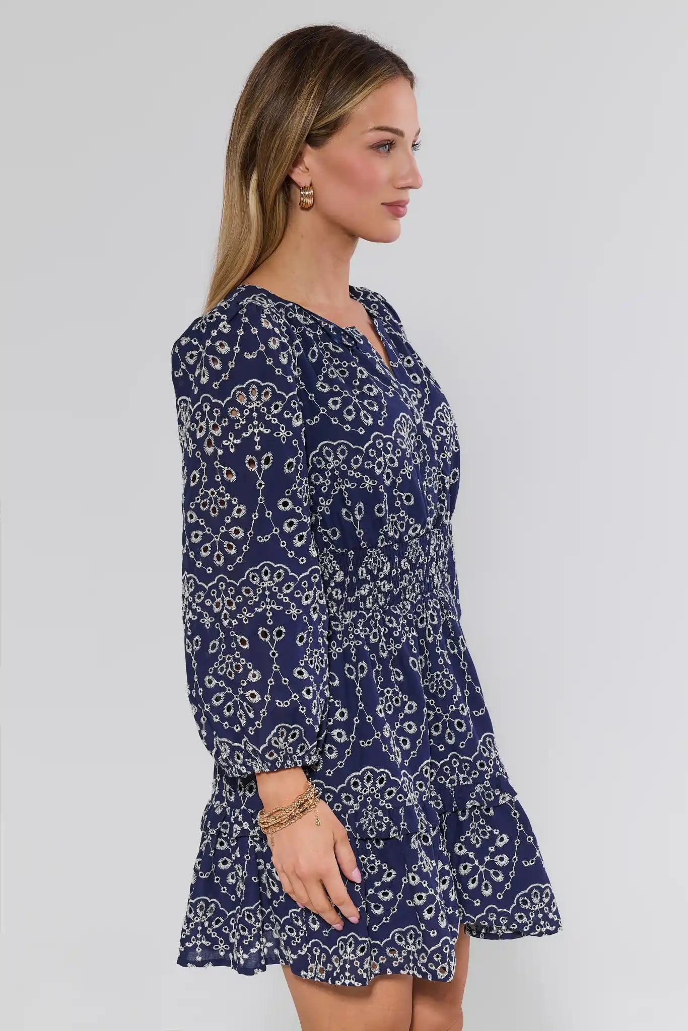 Woman wearing a navy blue patterned dress on a white background