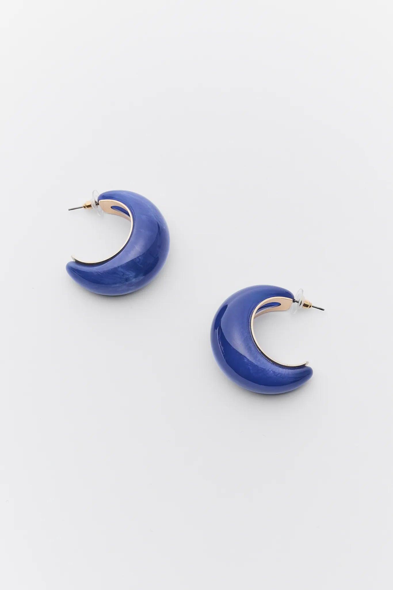 Blue crescent moon-shaped Tristan Blue Marble Hoop Earrings on a white background