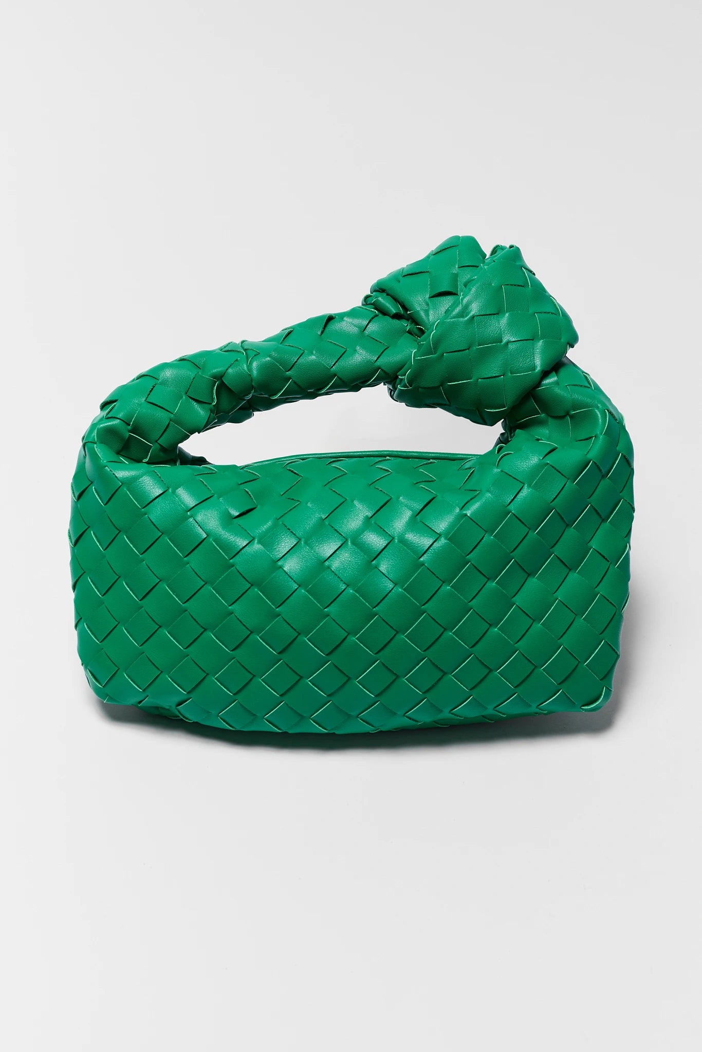 Green woven handbag on a light gray background