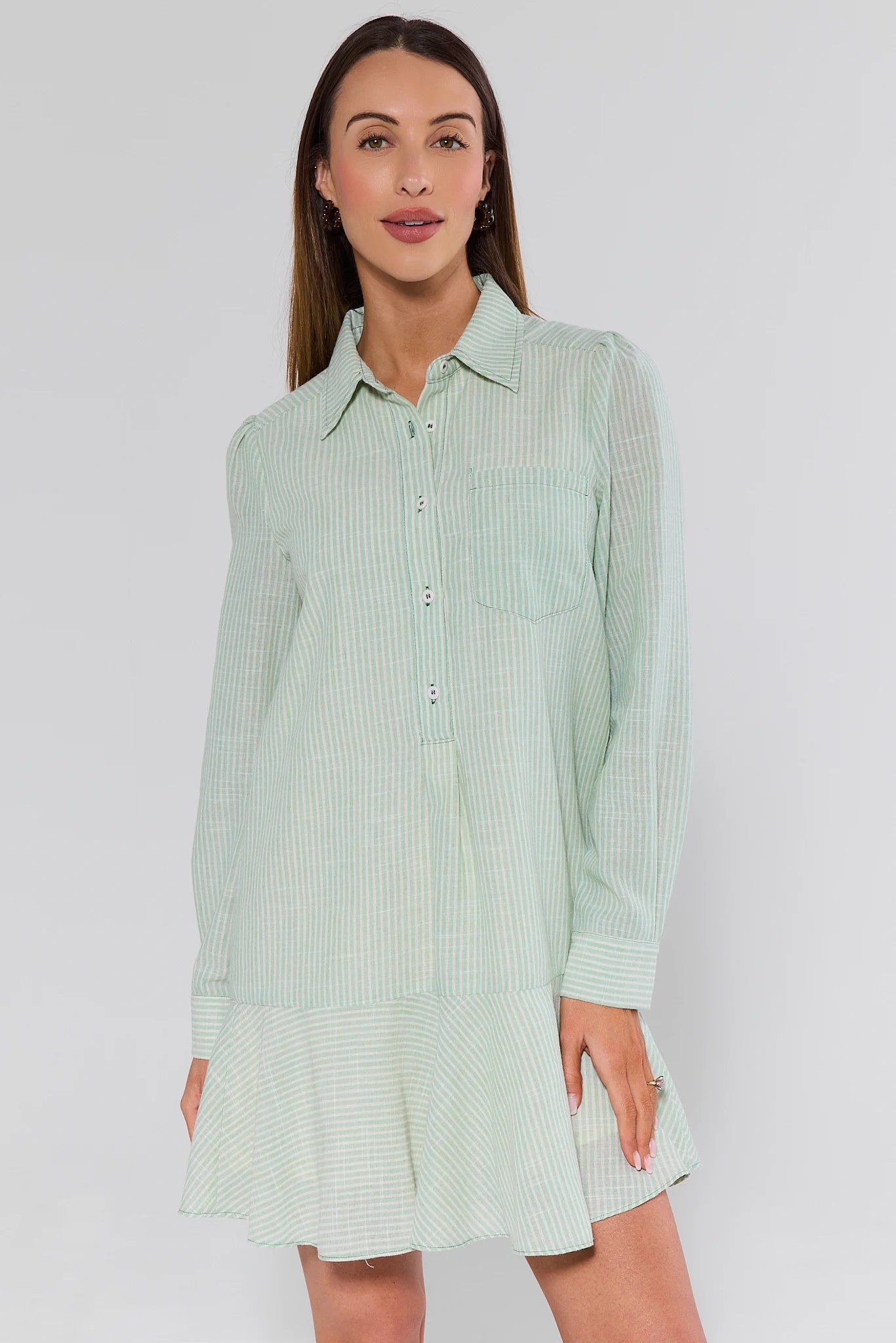 Woman wearing a light green checkered dress against a white background