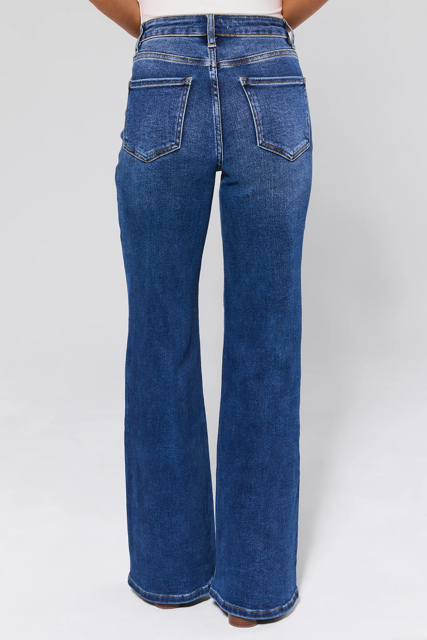 Woman wearing a light blue sweater with patterned design and Linda Dark Wash Wide Leg Jeans on a white background