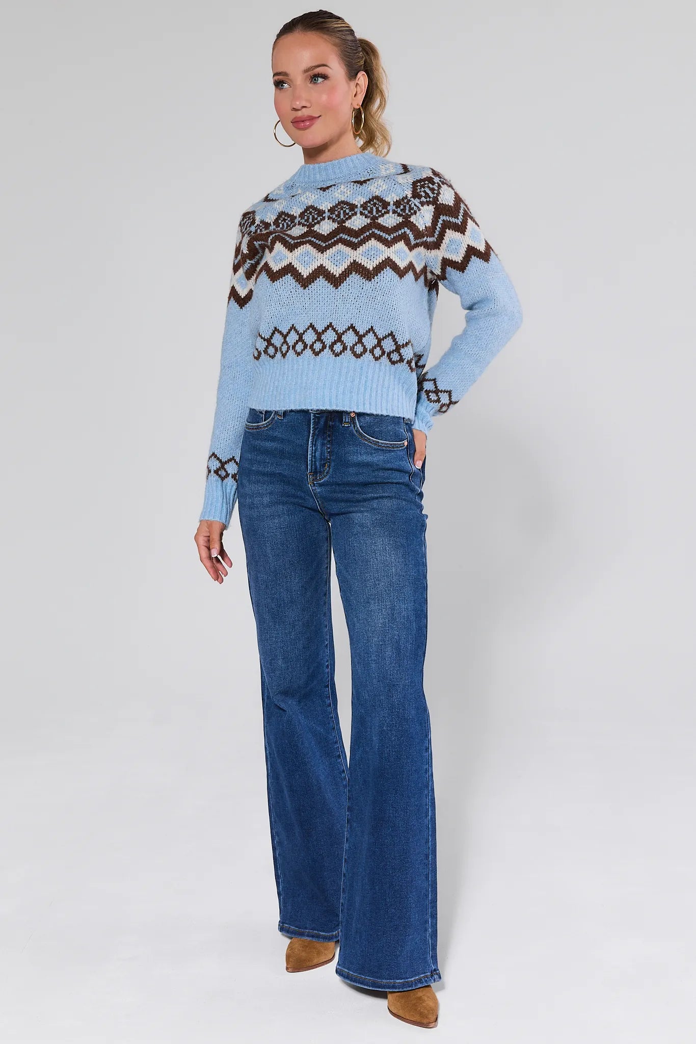 Woman wearing a light blue sweater with patterned design and Linda Dark Wash Wide Leg Jeans on a white background