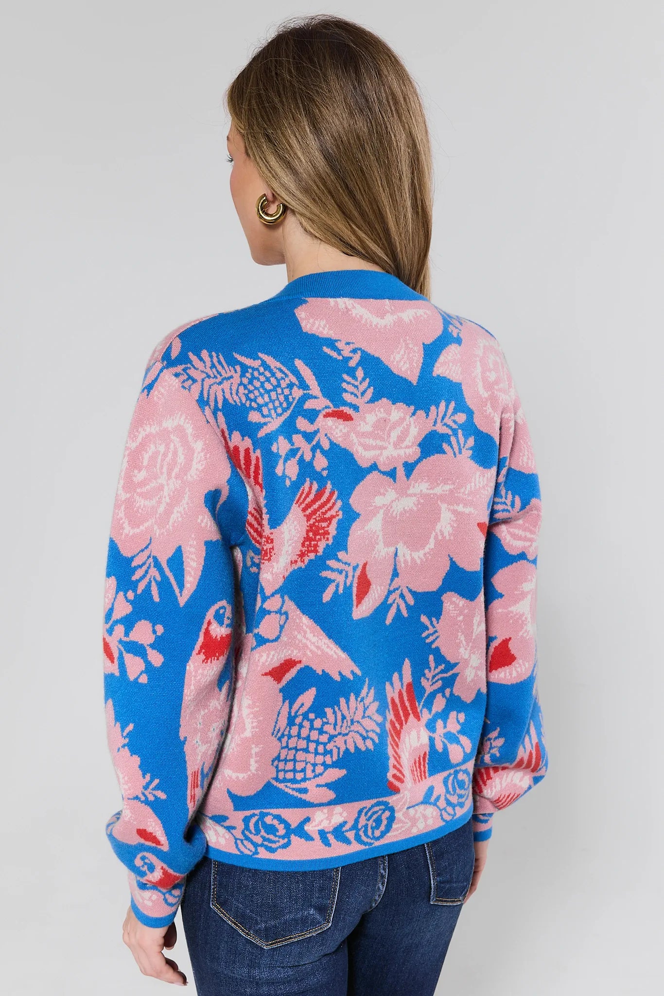 Woman wearing a colorful floral-patterned jacket against a plain background