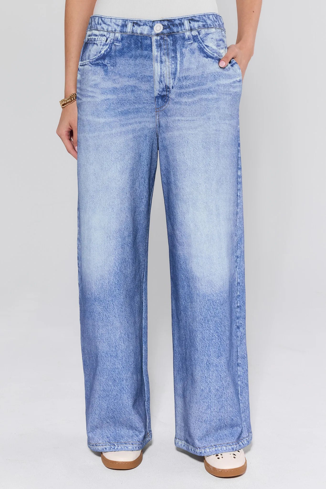 Person wearing light blue cotton jeans on a white background