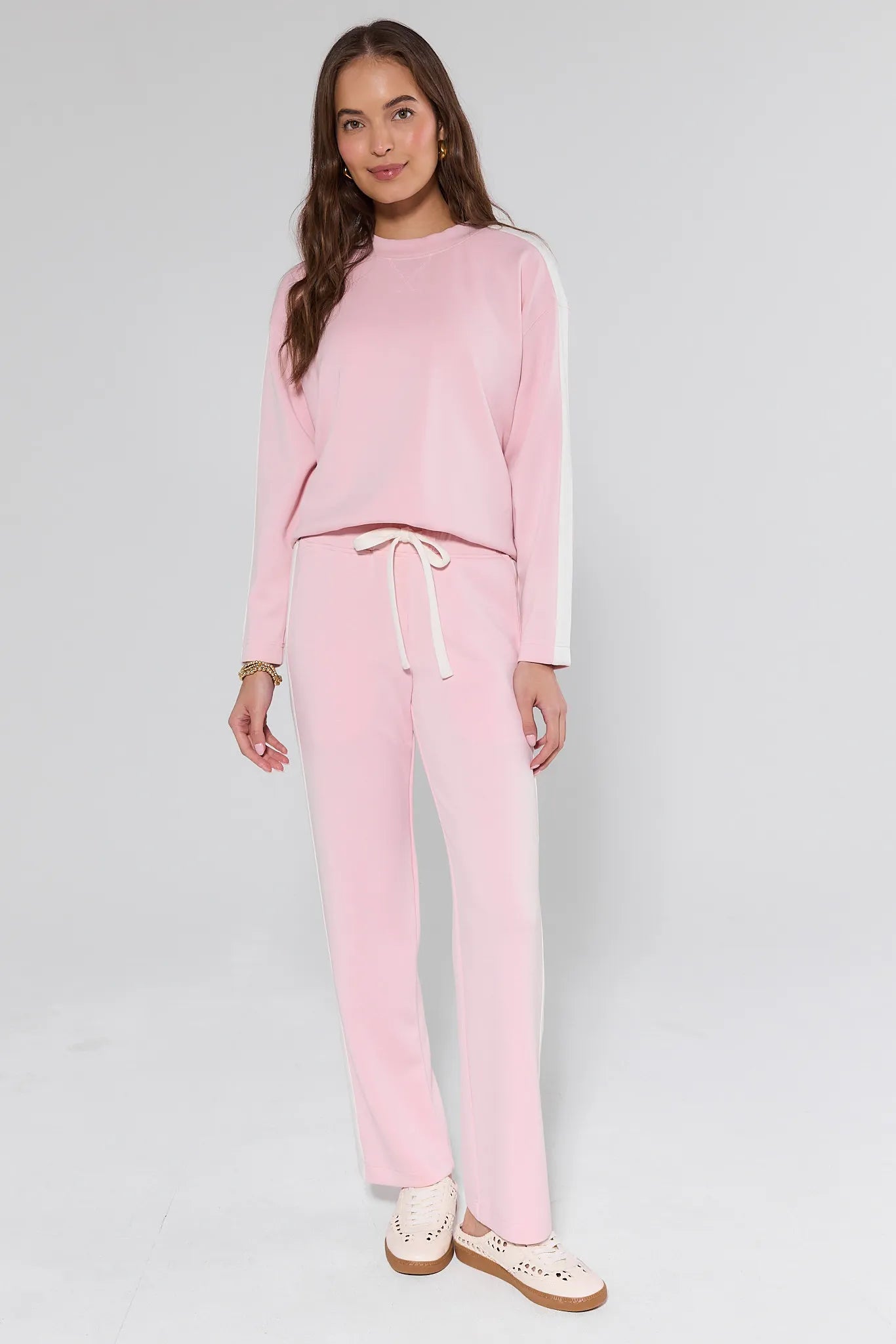 Woman wearing a pink outfit with a white background