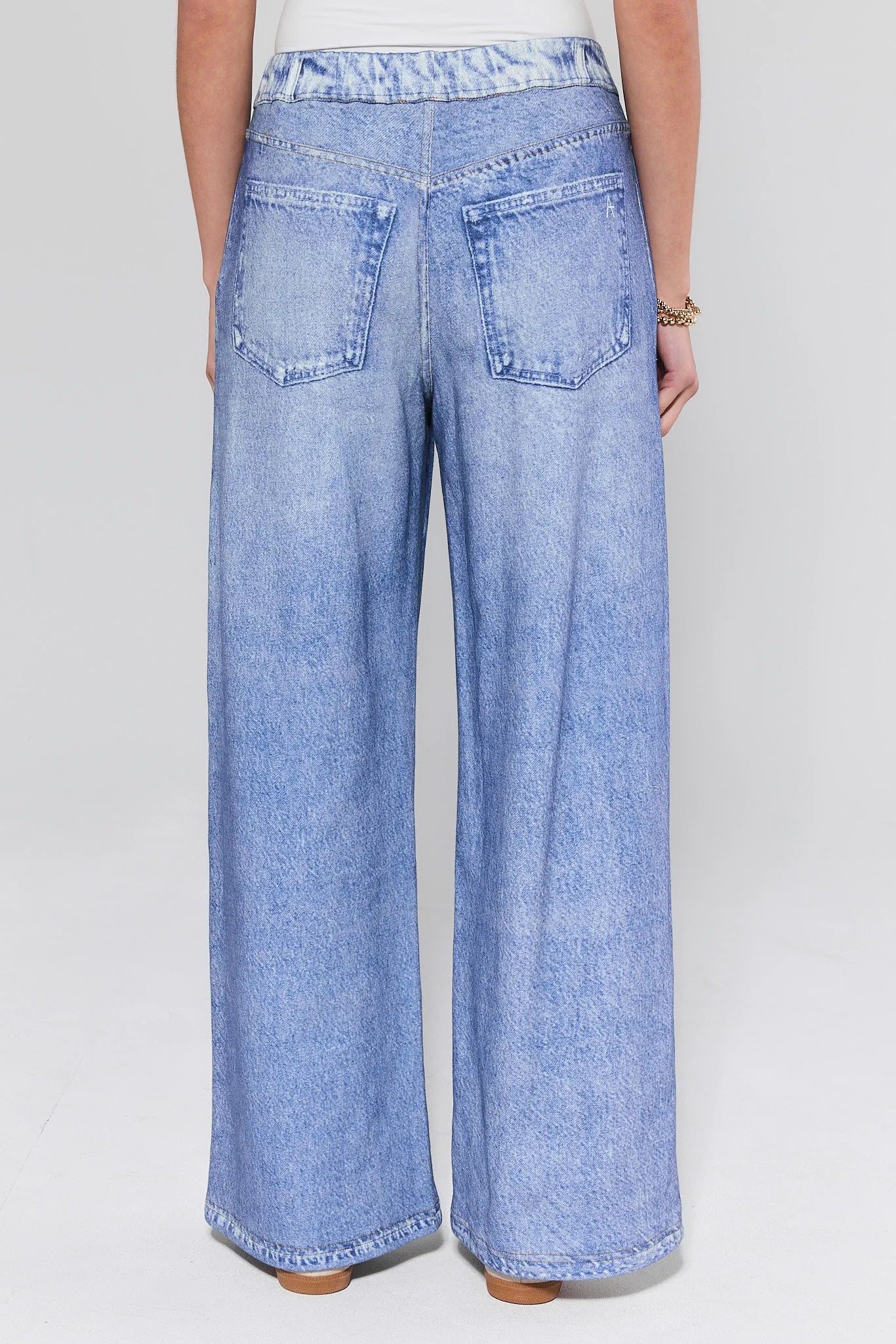 Light blue wide-leg jeans worn by a person on a plain background