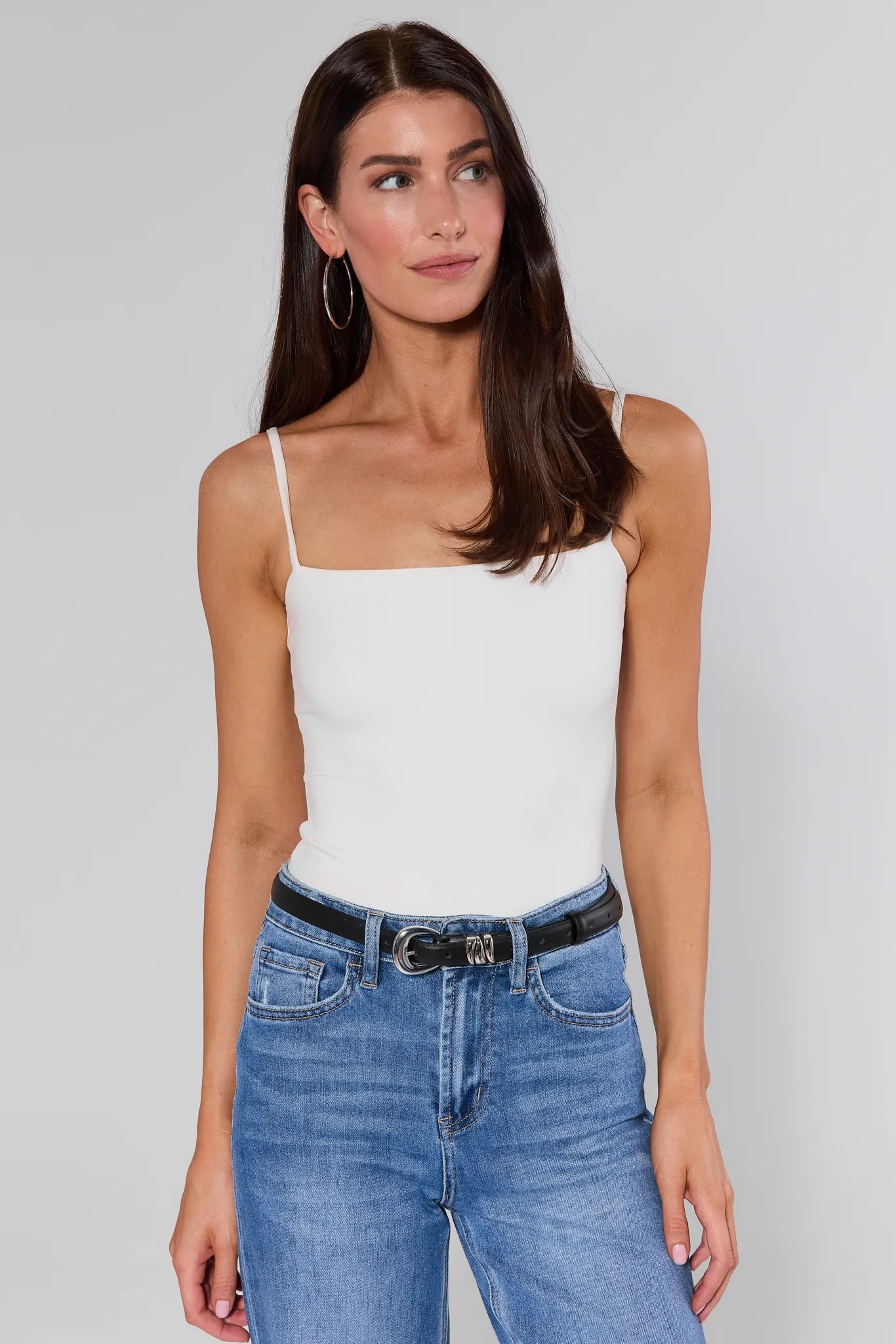 Caroline Black Keeper Belt on woman in white top and blue jeans