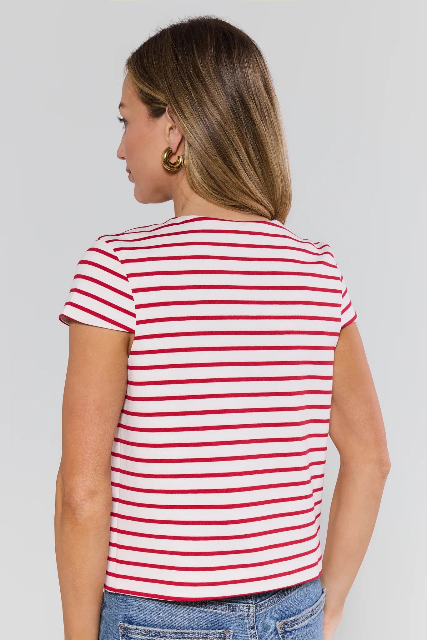 Woman wearing a red and white striped shirt against a plain background
