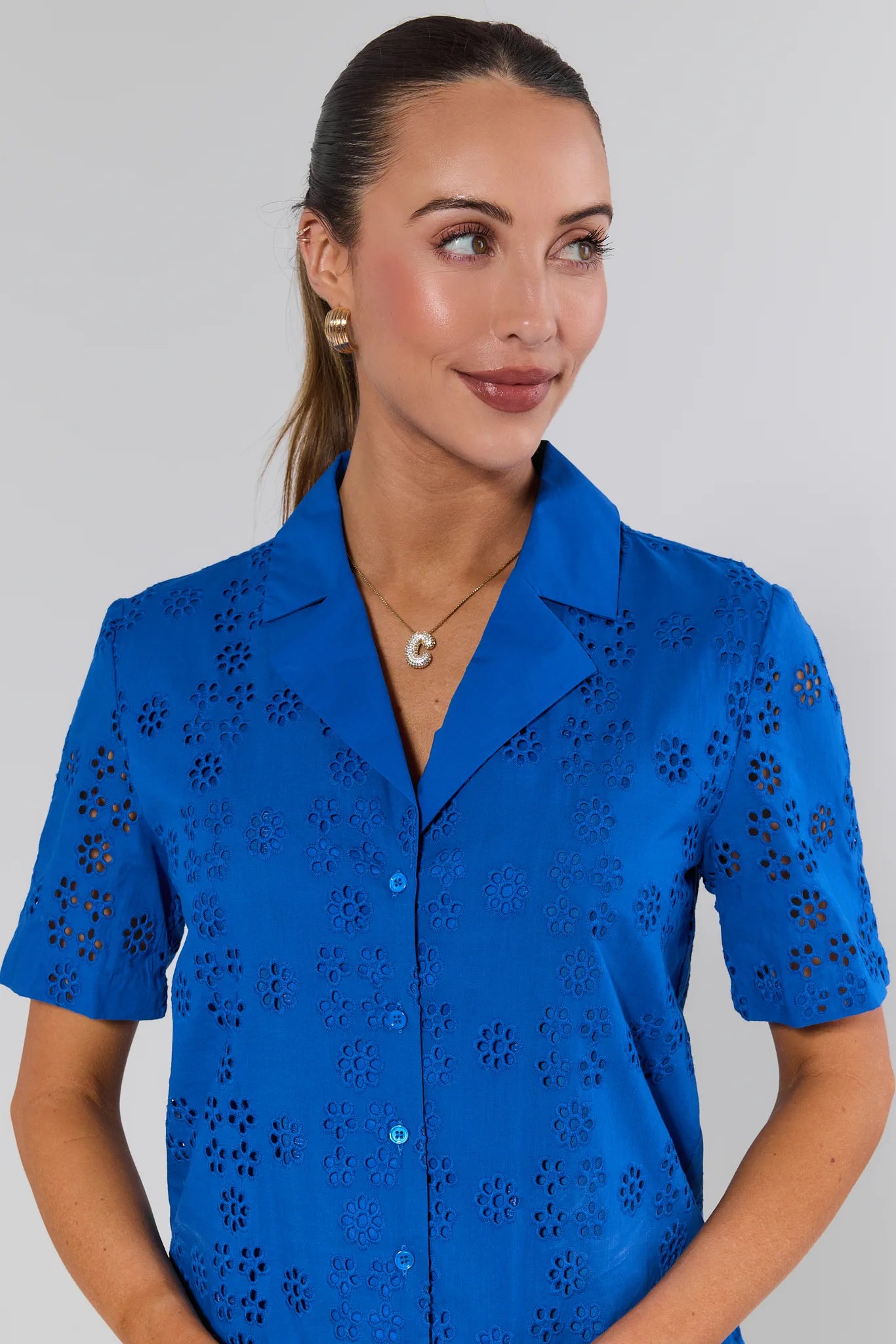 Woman wearing a blue blouse with a floral pattern on a gray background