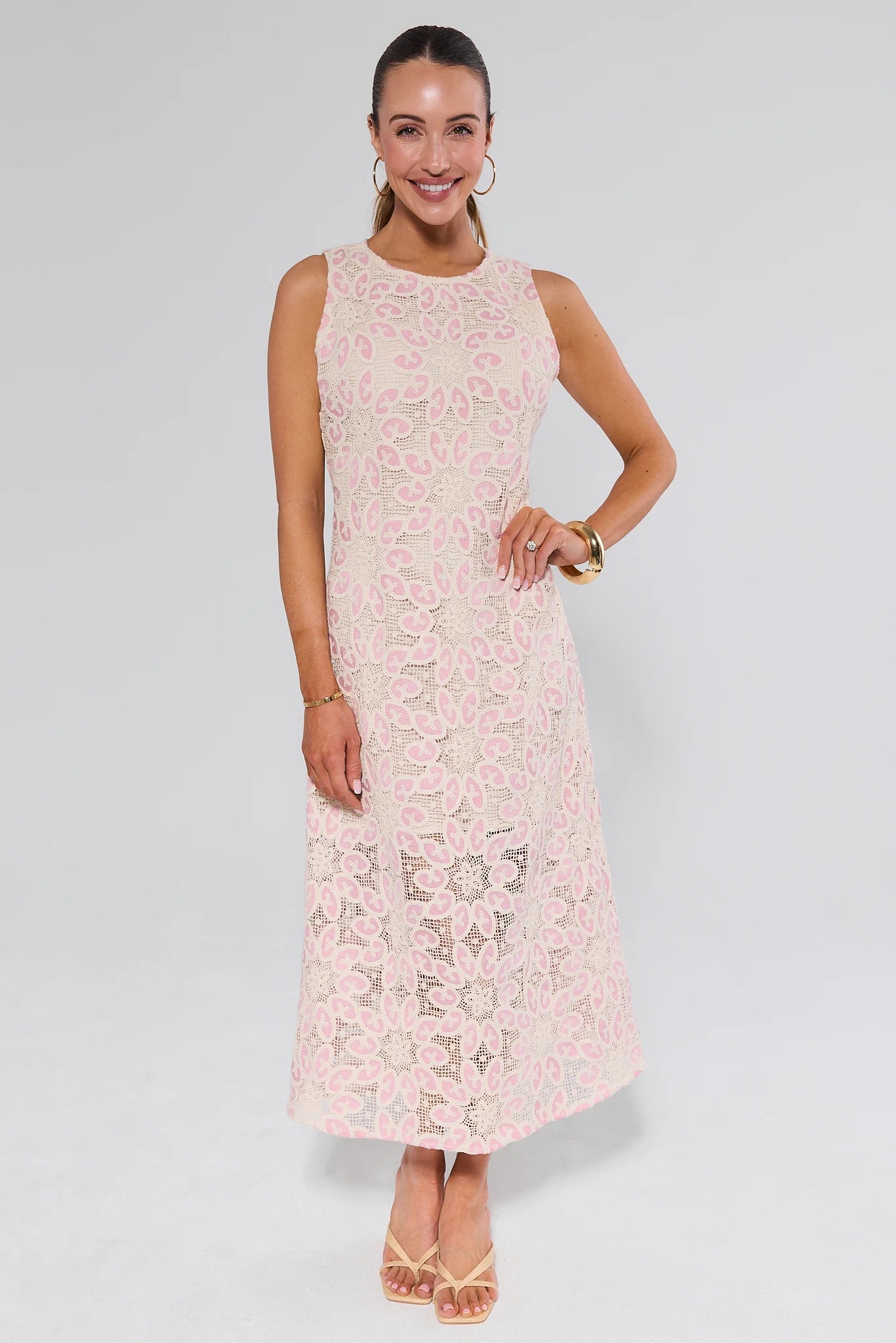 Woman wearing a light pink lace dress on a white background