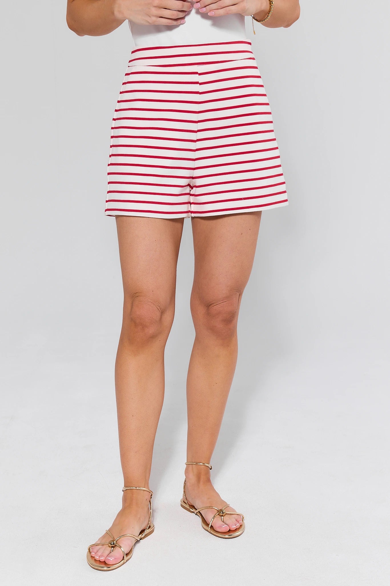 Person wearing red and white striped shorts on a plain background