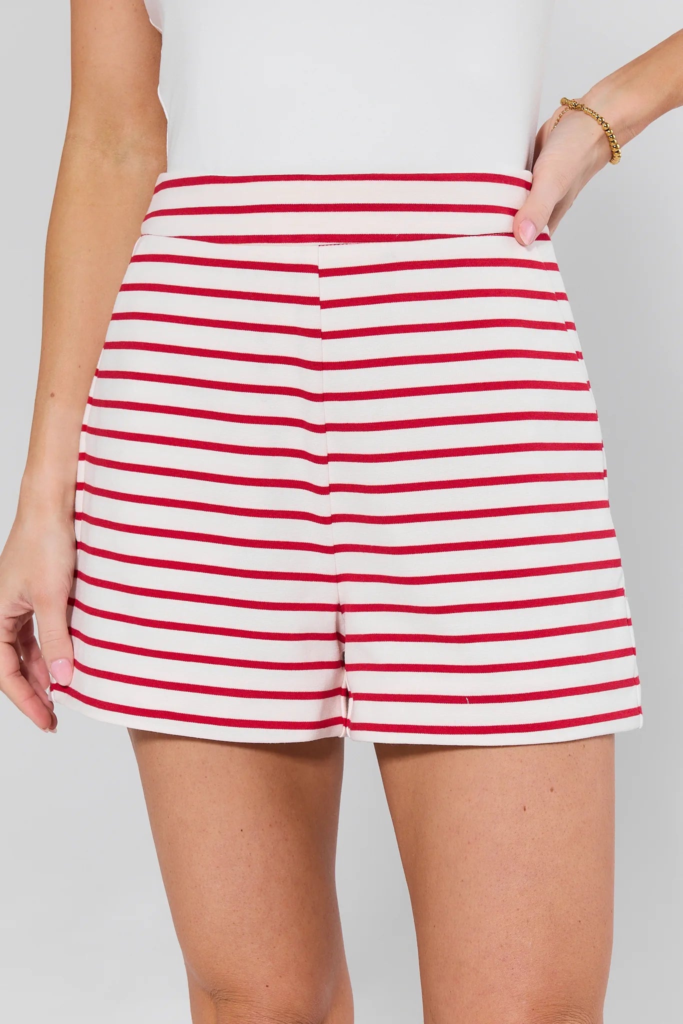 Red and white striped shorts worn by a person on a plain background
