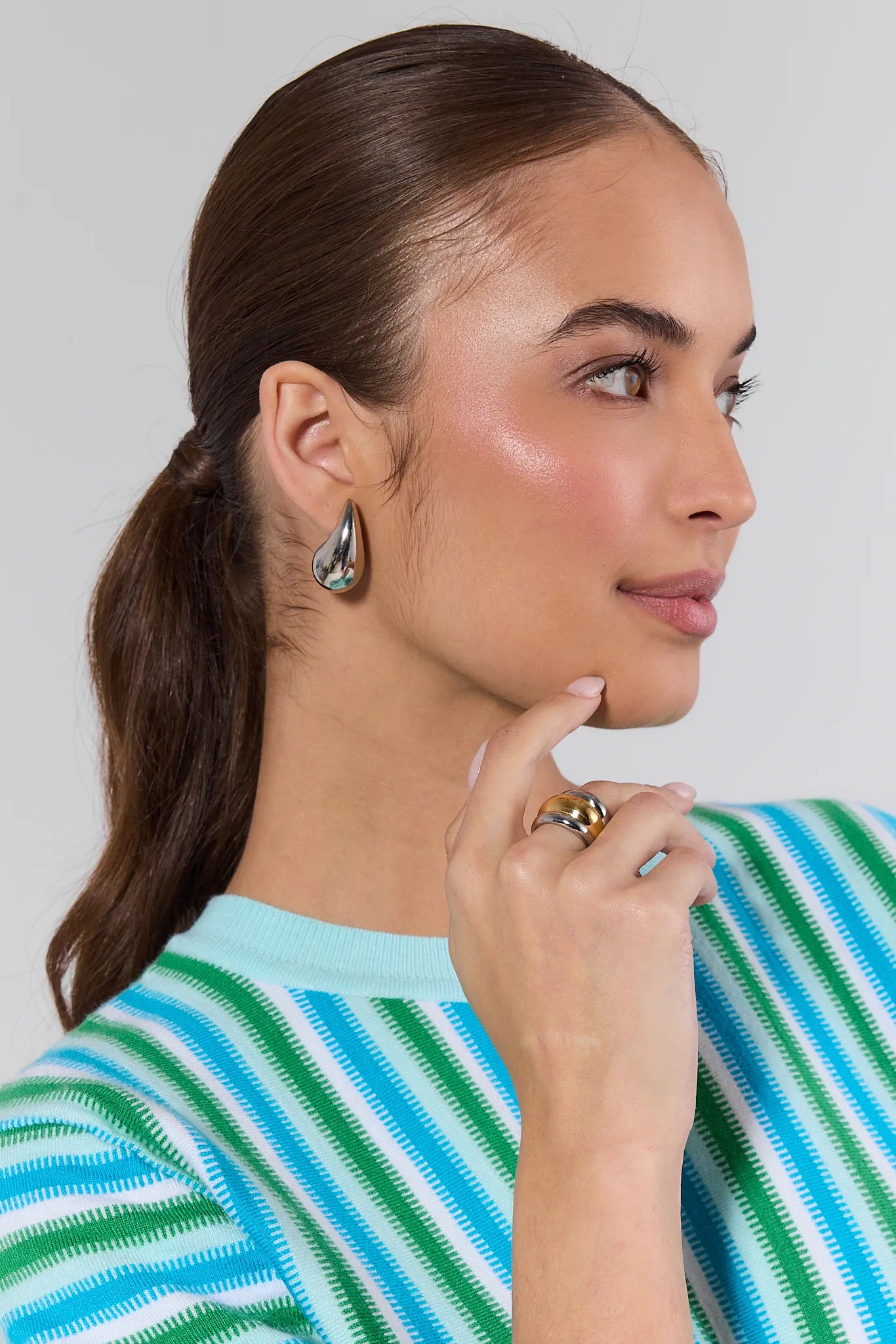 Woman wearing earrings and a striped shirt with Daley Two Tone Fluted Ring against a plain background
