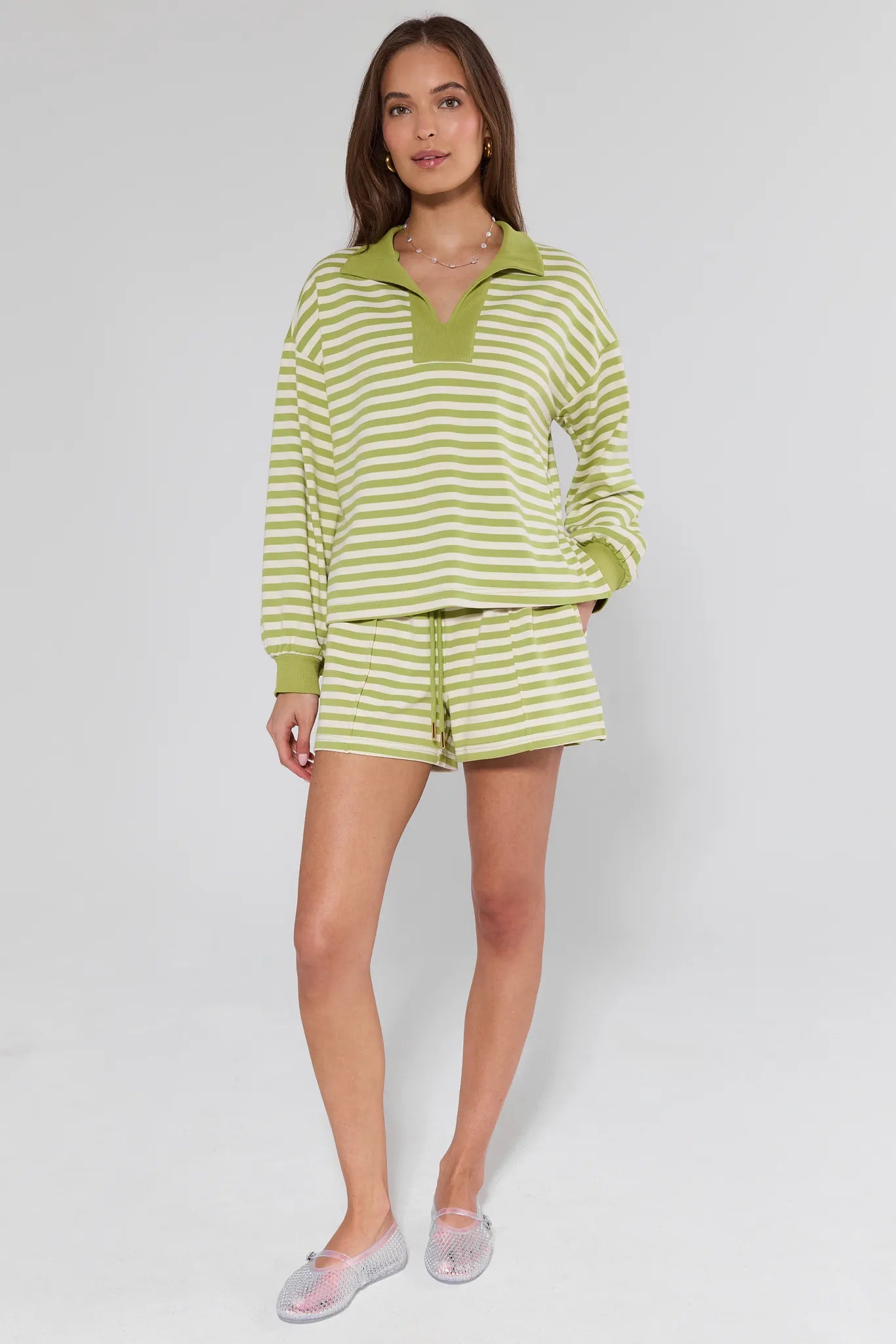 Woman wearing a green and white striped outfit on a white background