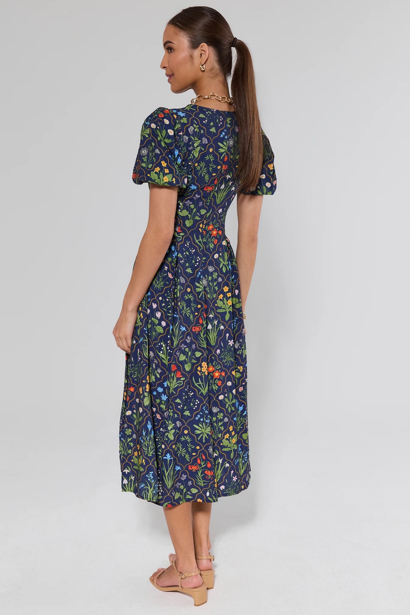 Woman wearing a floral dress on a plain background
