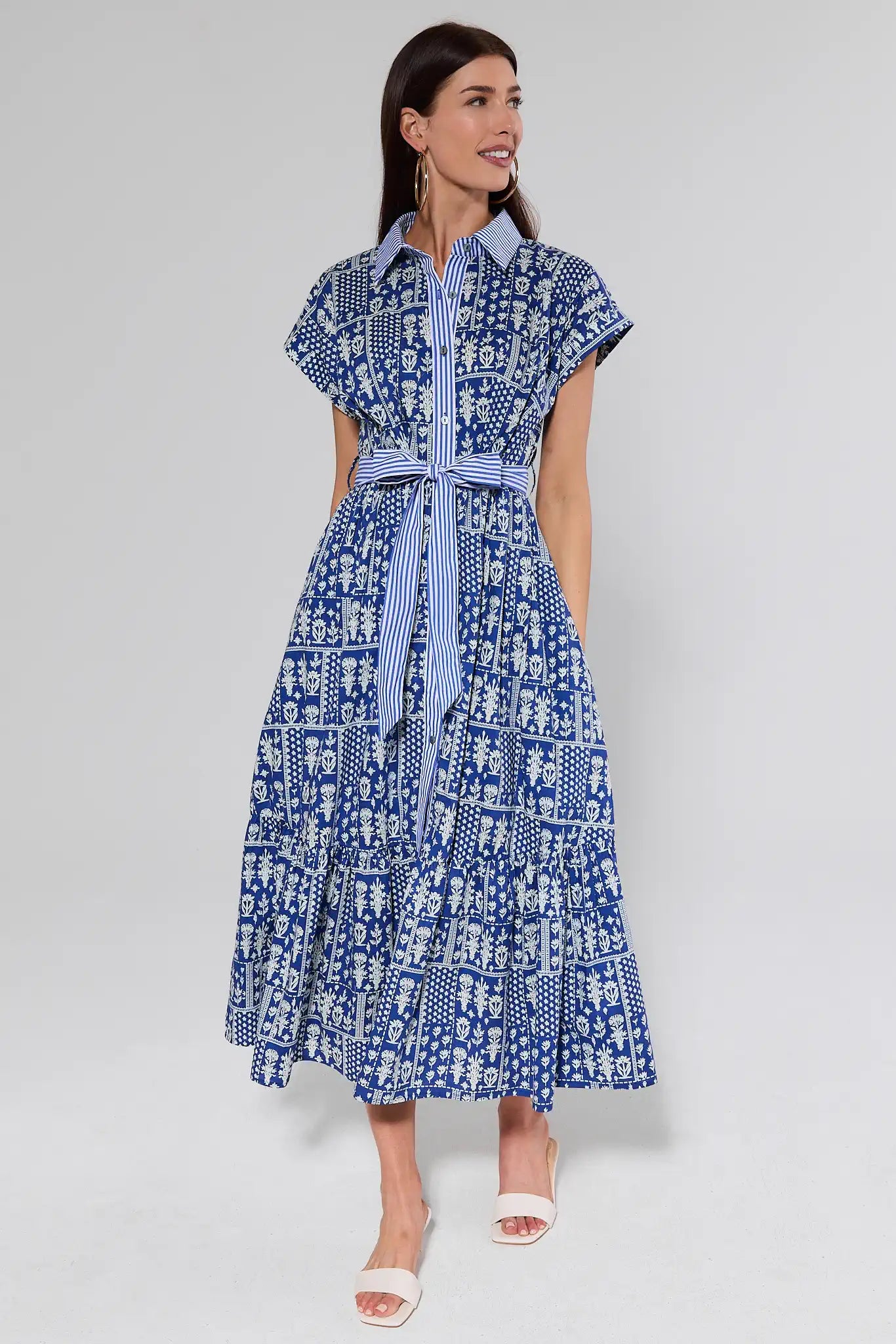 Woman wearing a blue patterned dress on a white background