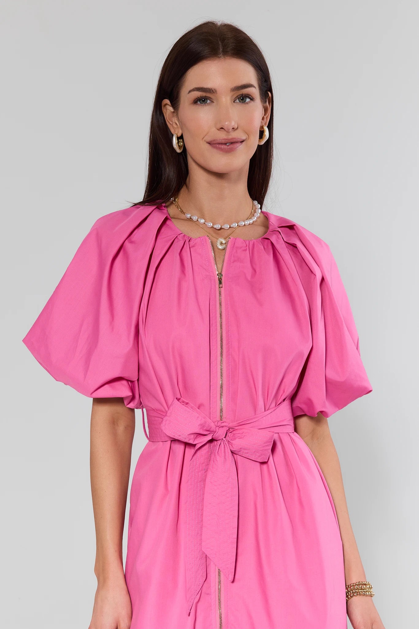 Woman wearing a pink dress with a plain background