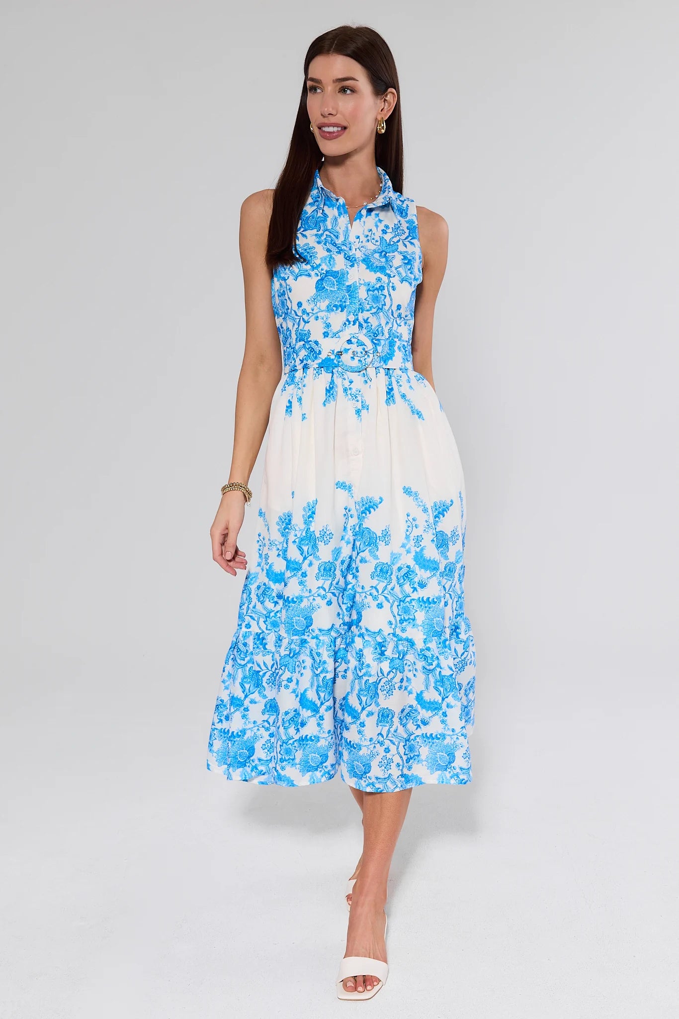 Woman wearing a blue and white floral dress on a gray background