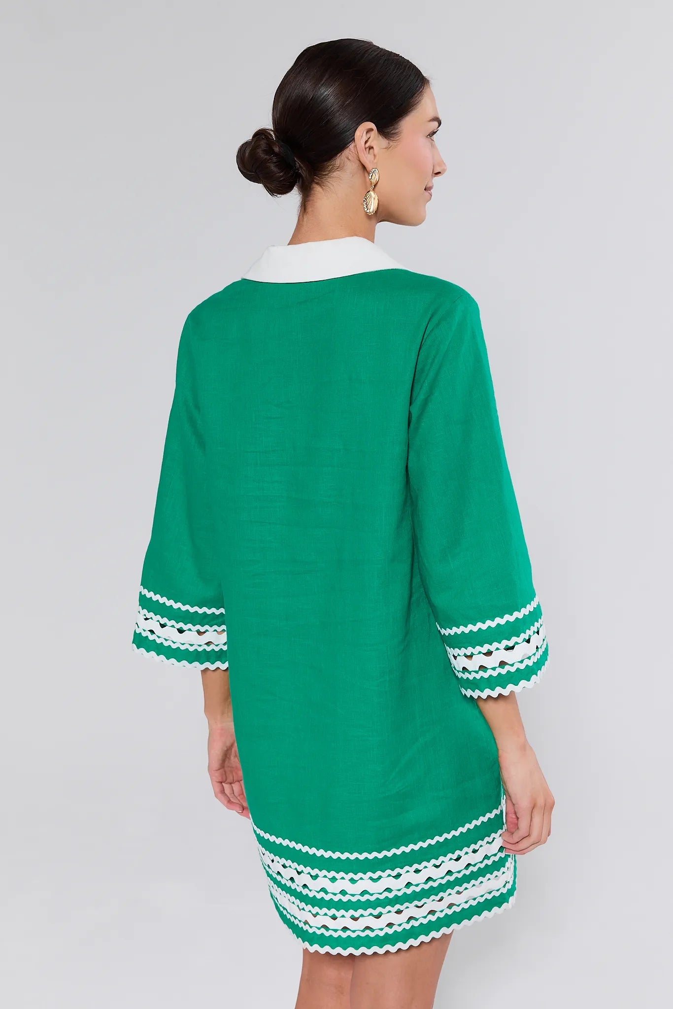 Green dress with white trim on a plain background
