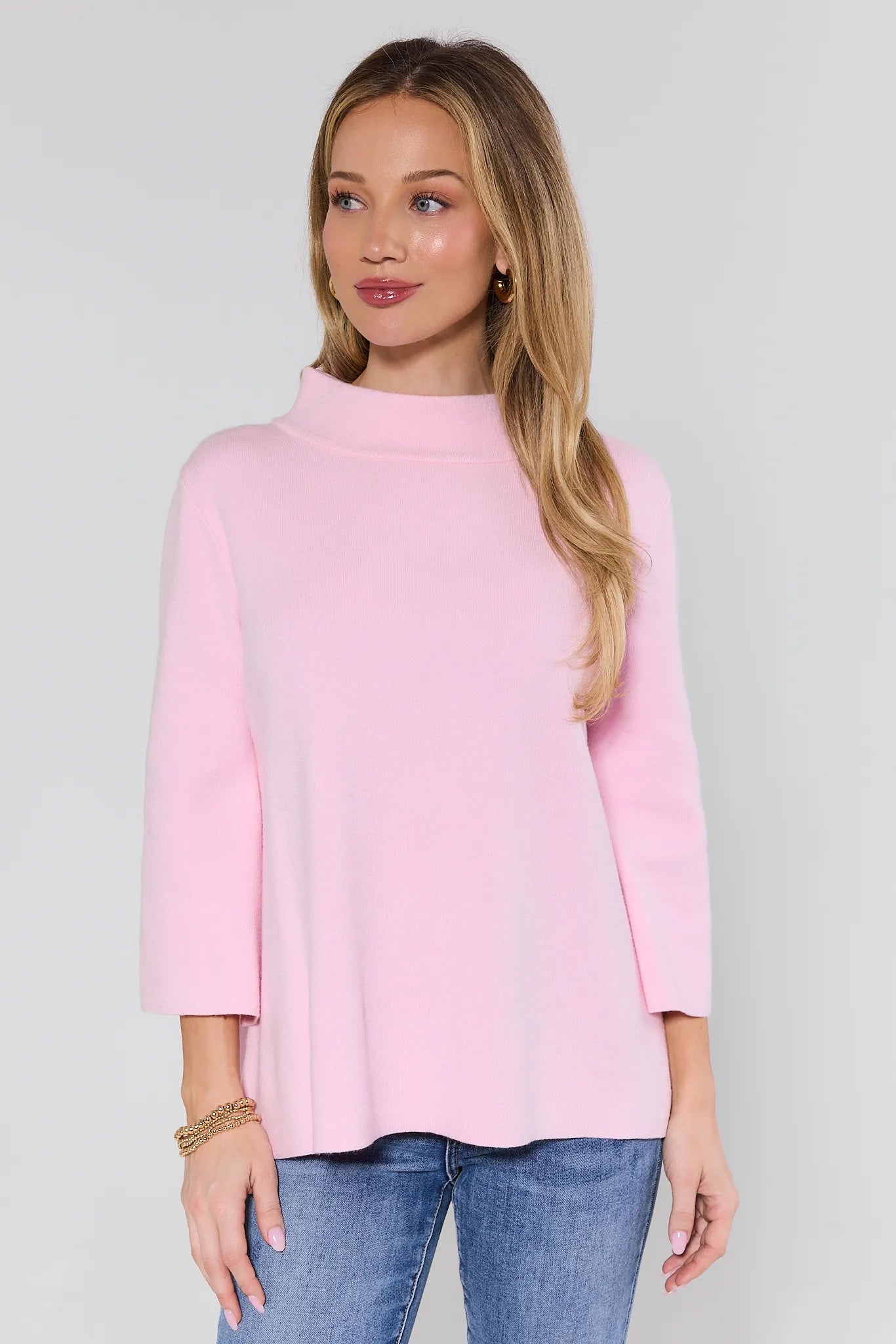 woman wearing a pink sweater on a white background