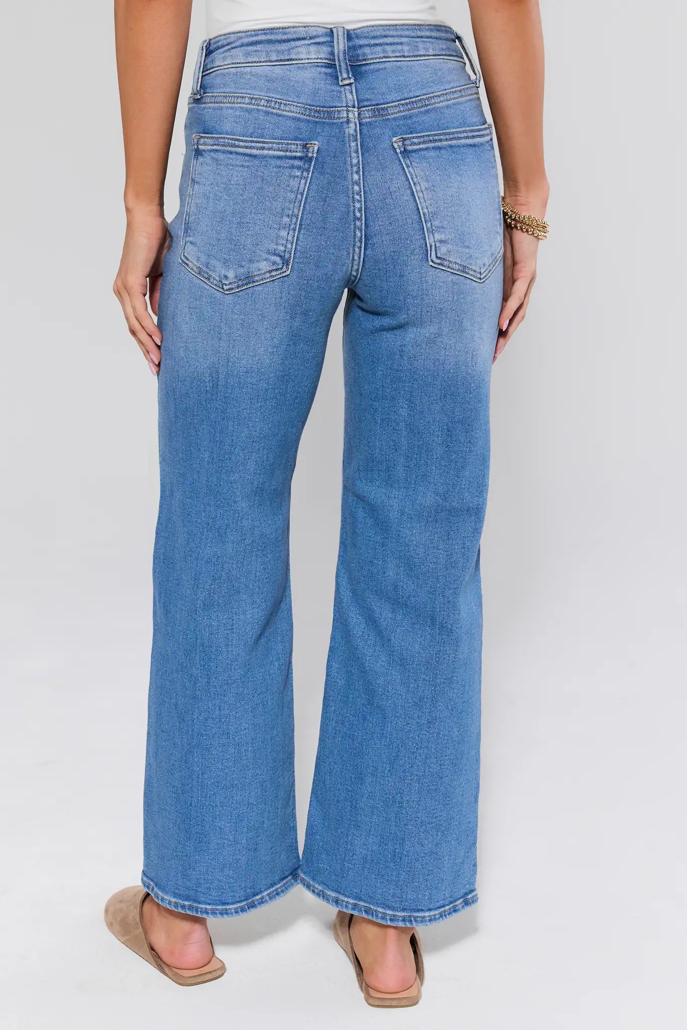 Blue jeans worn by a person on a white background