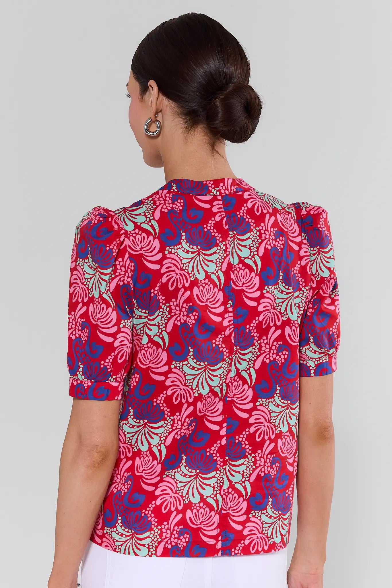 Woman wearing a red floral blouse against a white background