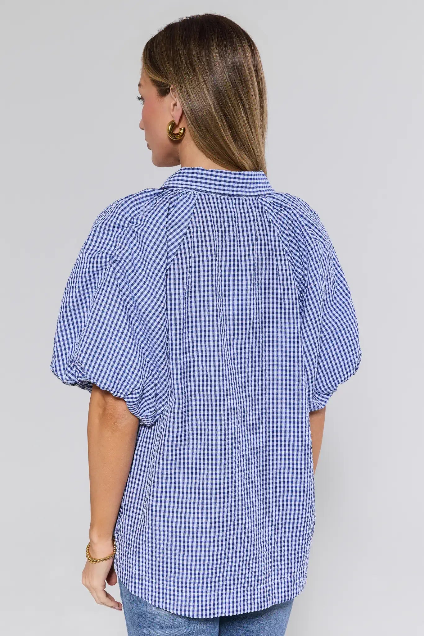 Woman wearing a blue checkered blouse on a gray background