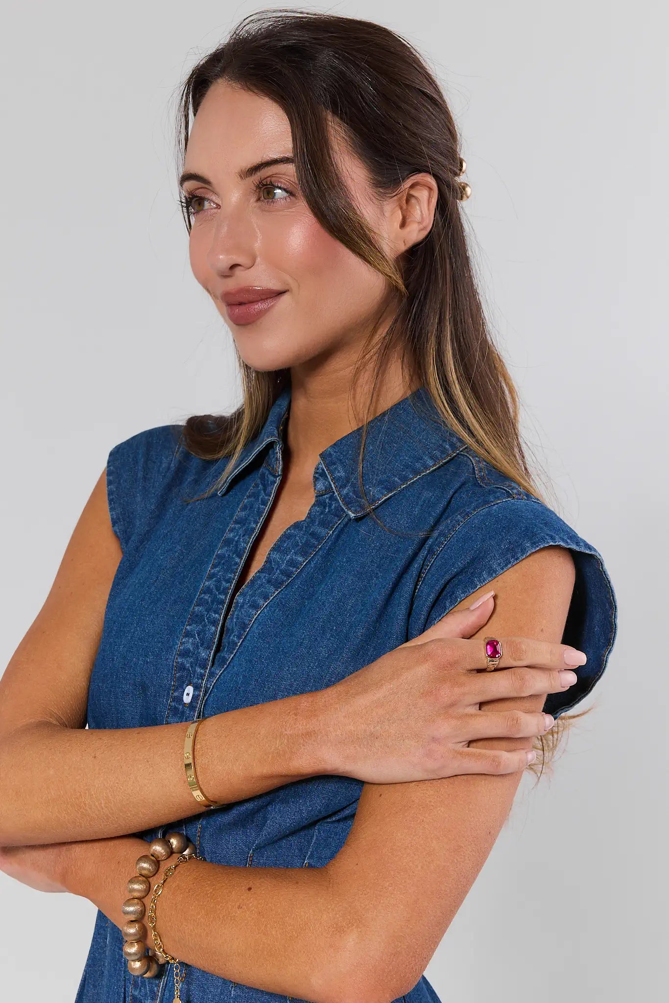 Woman wearing a denim shirt with a plain background