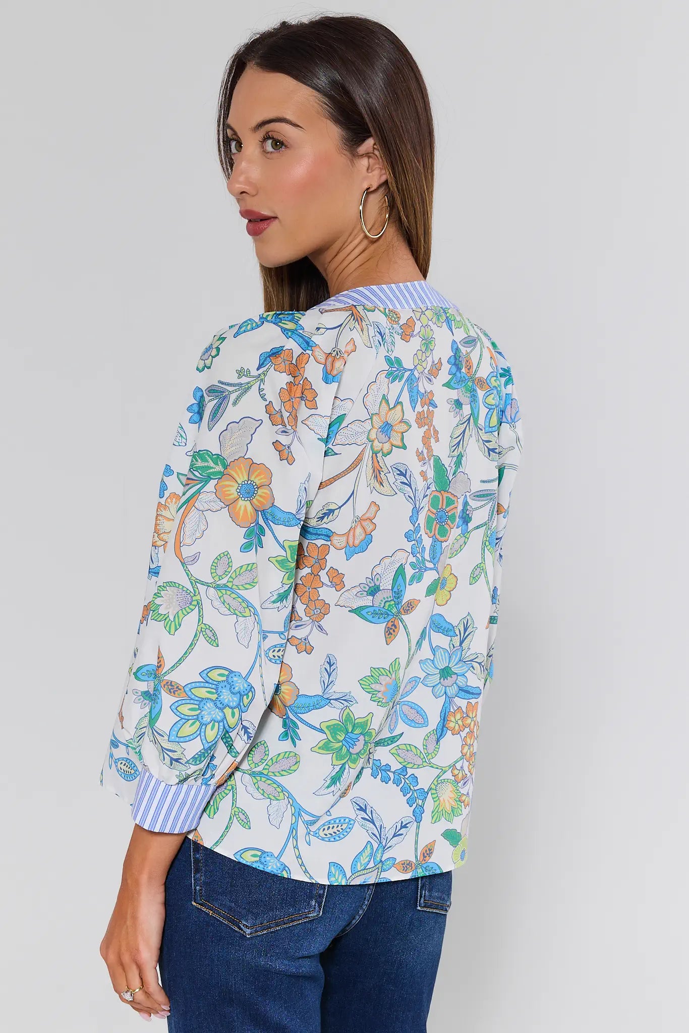 Woman wearing a floral patterned top with a plain background