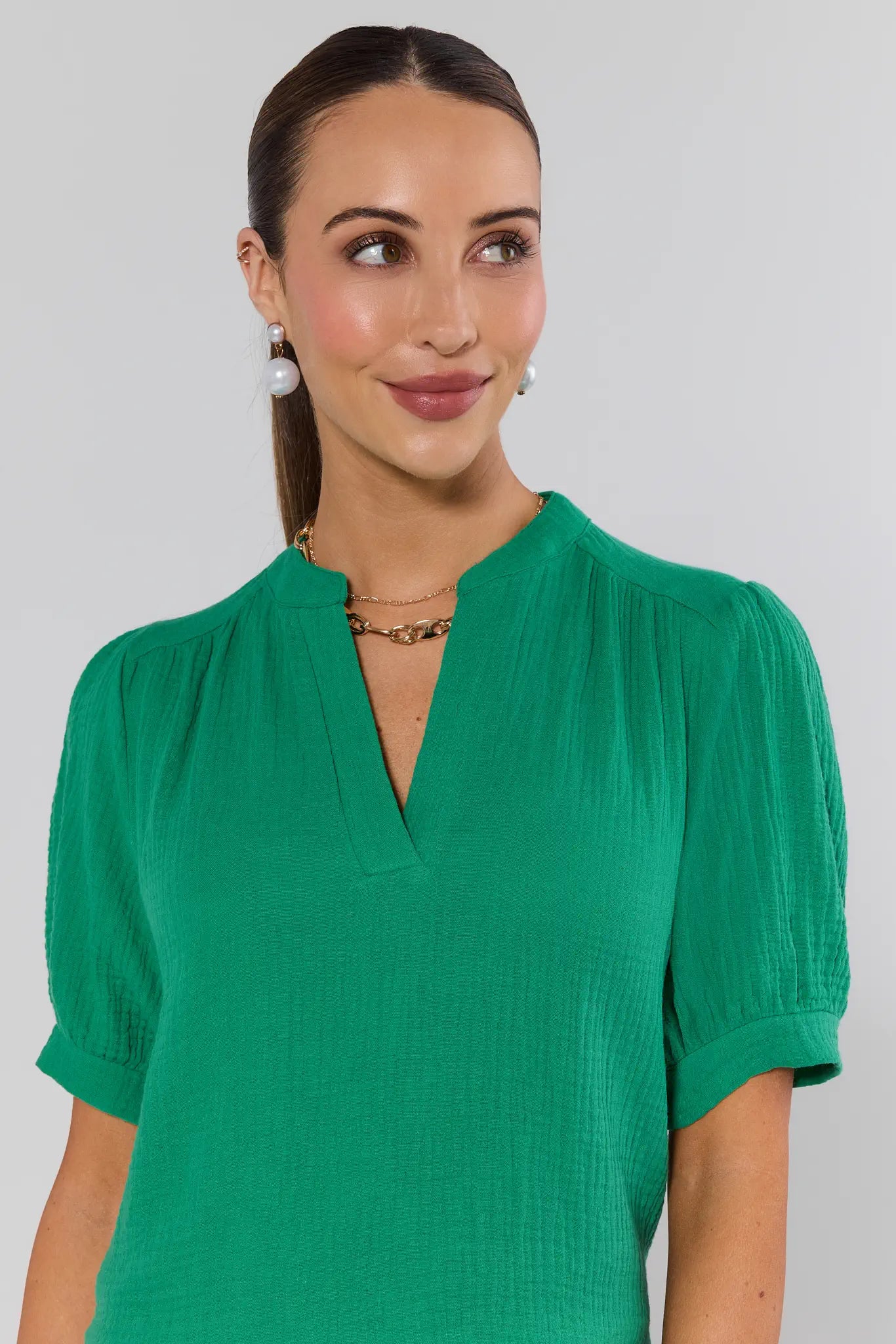 Woman wearing a green blouse against a plain background