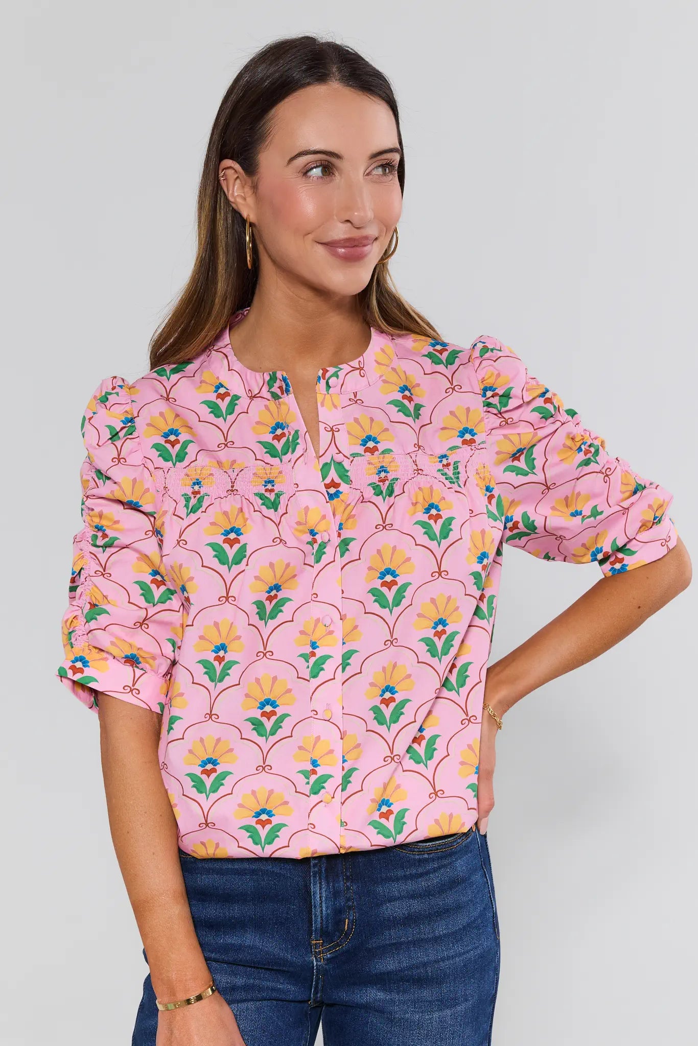 Woman wearing a pink floral blouse against a plain background