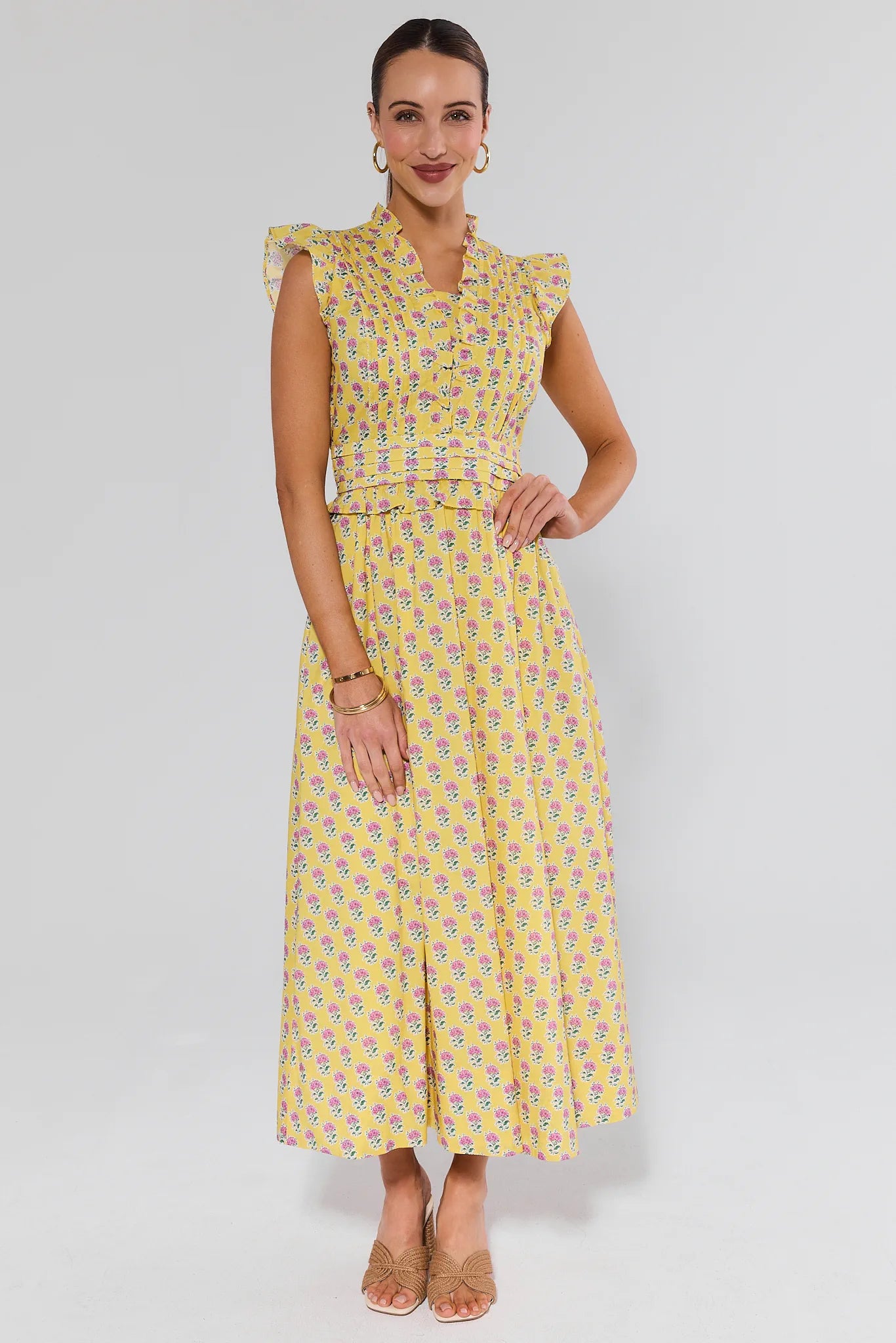 Woman wearing a yellow patterned dress on a white background