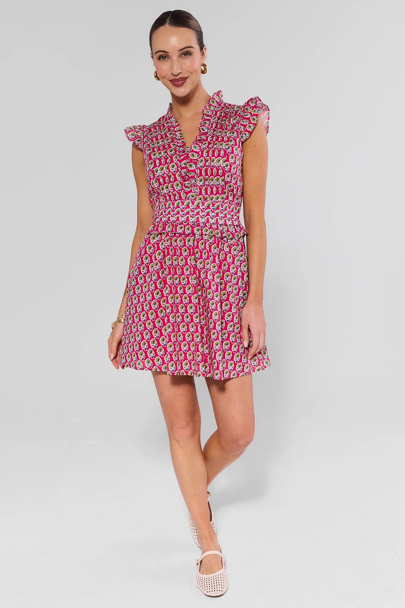 Woman wearing a pink patterned dress on a white background