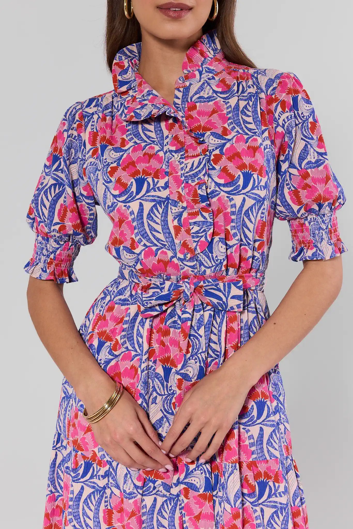 Woman wearing a colorful floral dress with a plain background