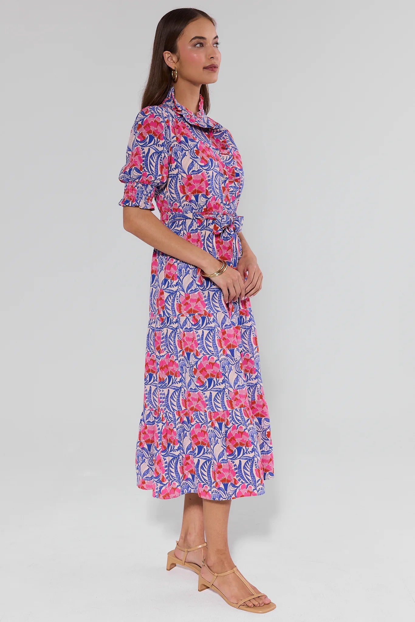Woman wearing a colorful floral dress on a white background