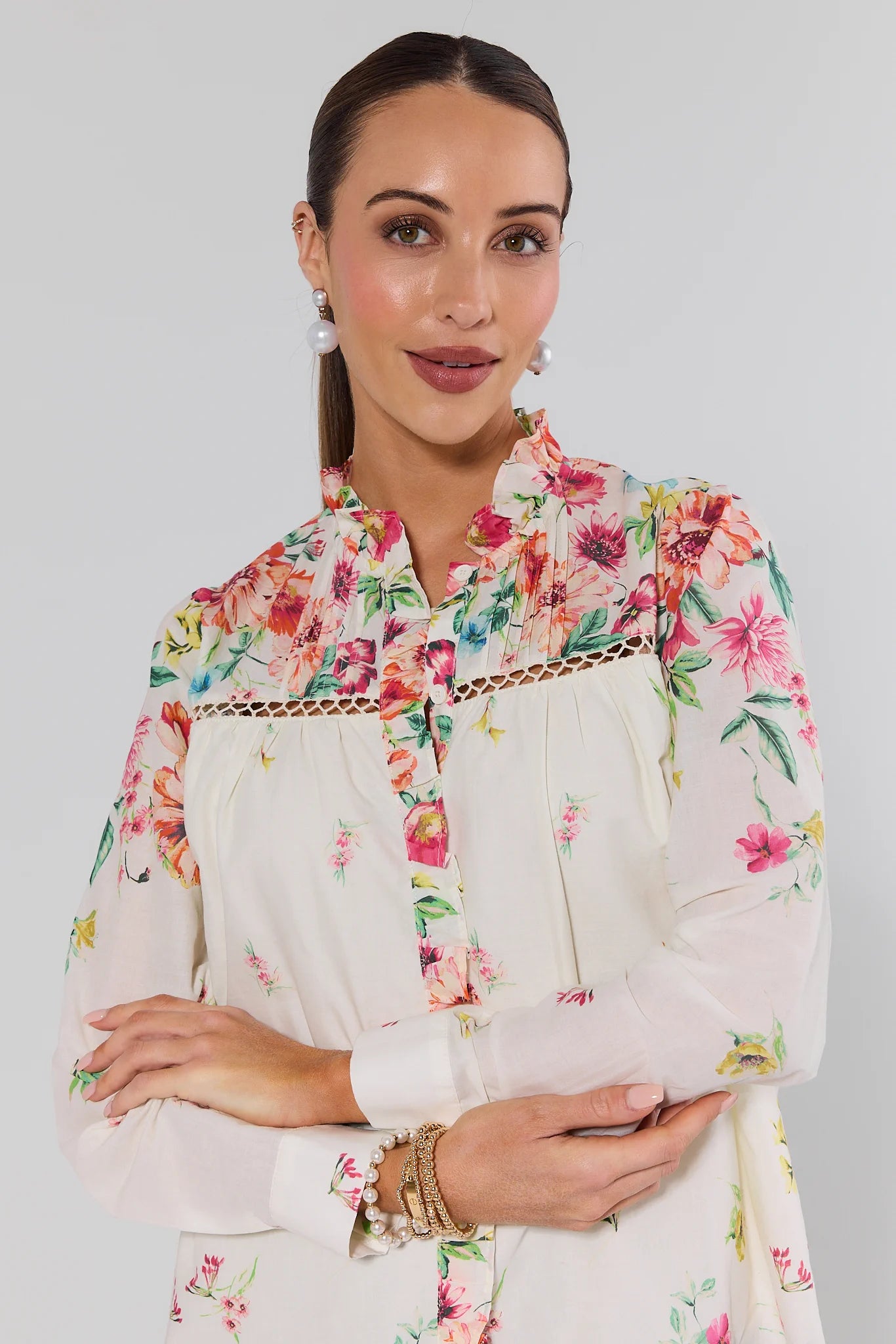 Woman wearing a floral blouse with a plain background