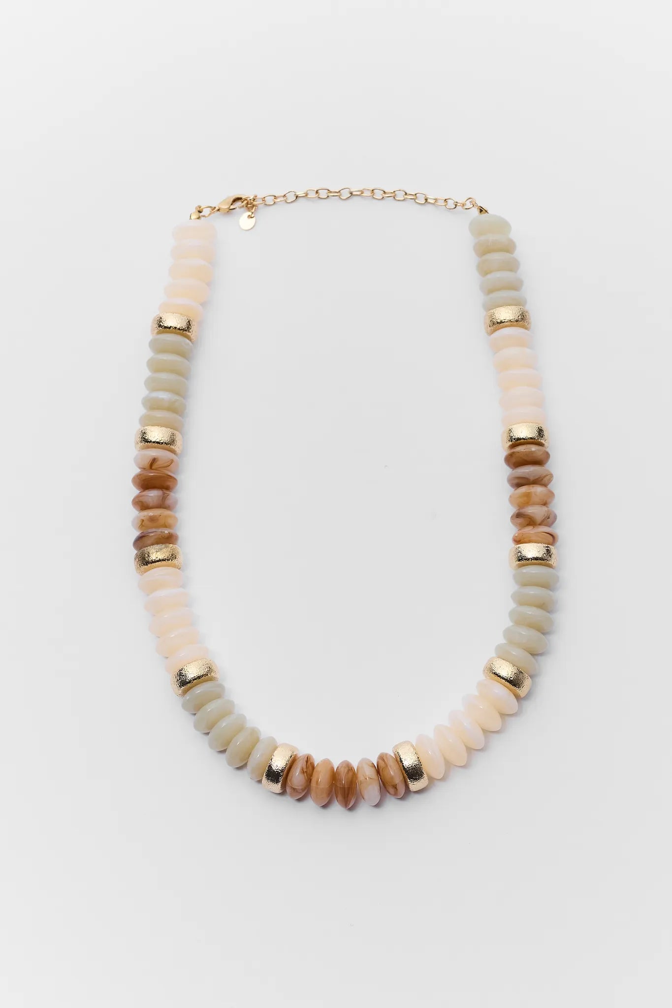Necklace with beige and gold beads on a light gray background